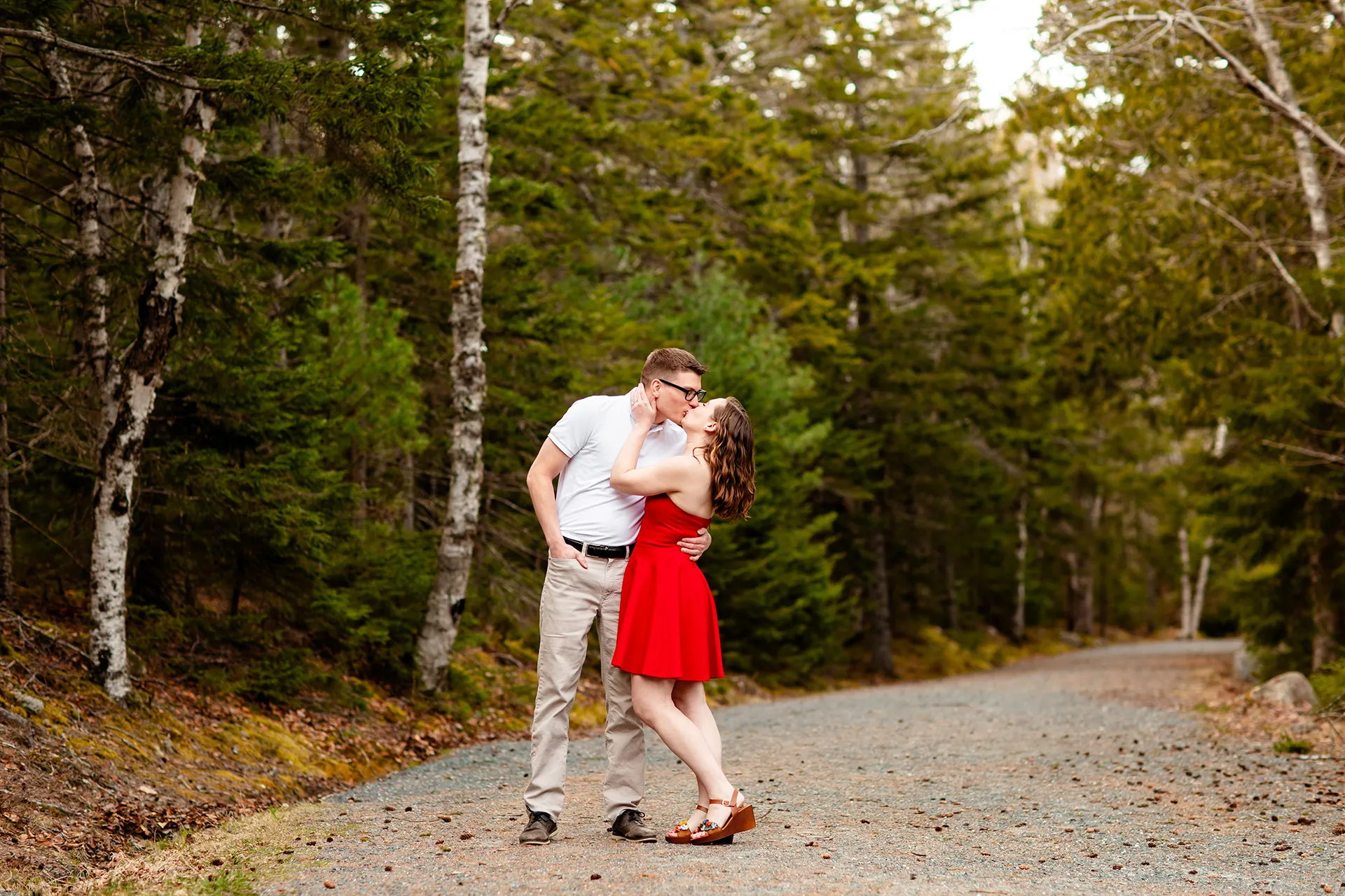 maine engagement photography chelsea mike 03 An engaged couple kiss on a path at Jordan Pond during an engagement session in Acadia National Park, Maine.