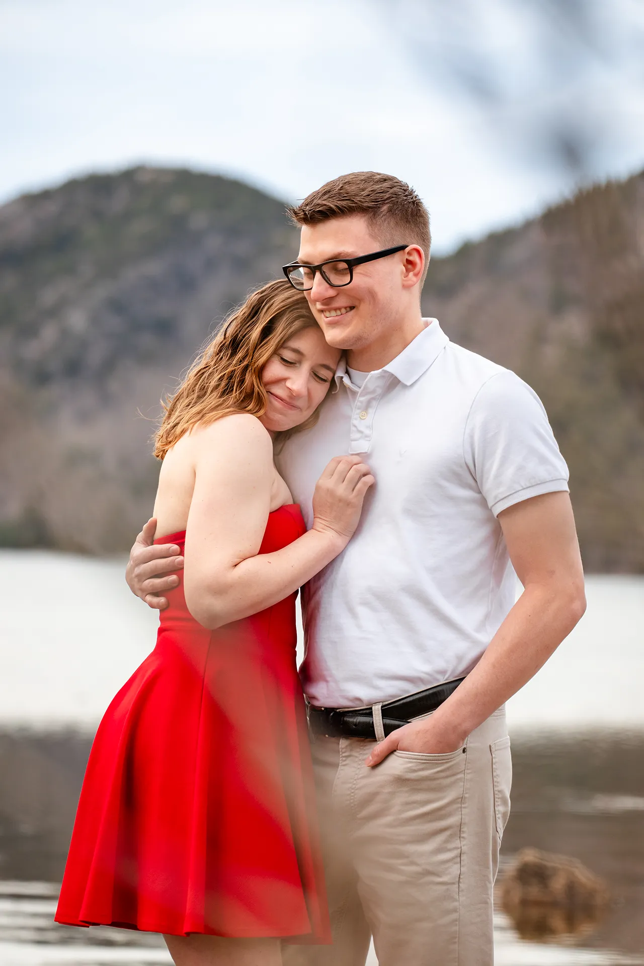 maine engagement photography chelsea mike 06 An engaged couple smile as they snuggle together during an engagement session at Jordan Pond in Acadia National Park, Maine.