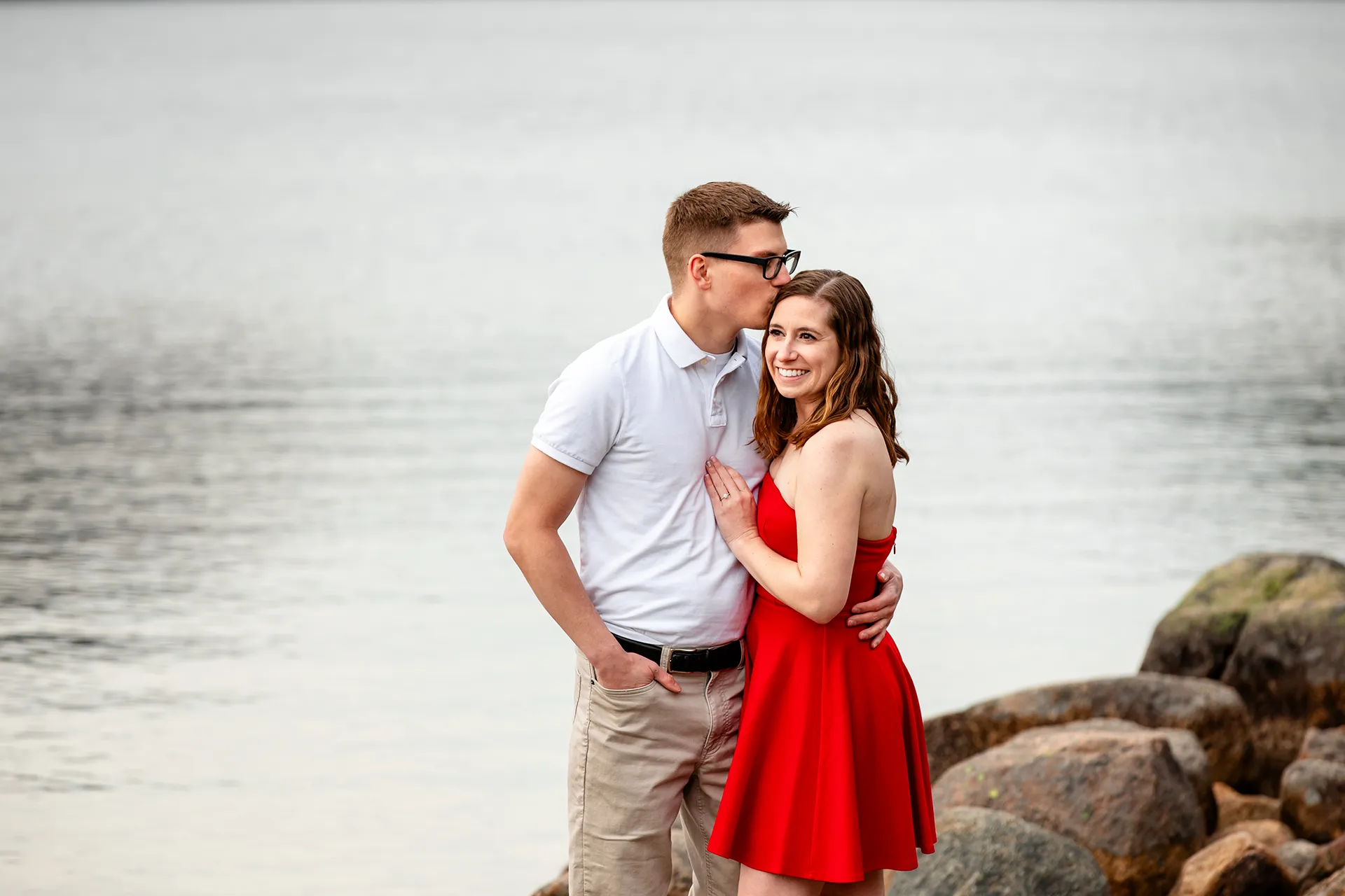 maine engagement photography chelsea mike 08 A man kisses a woman on the head during an engagement session at Jordan Pond in Acadia National Park, Maine.