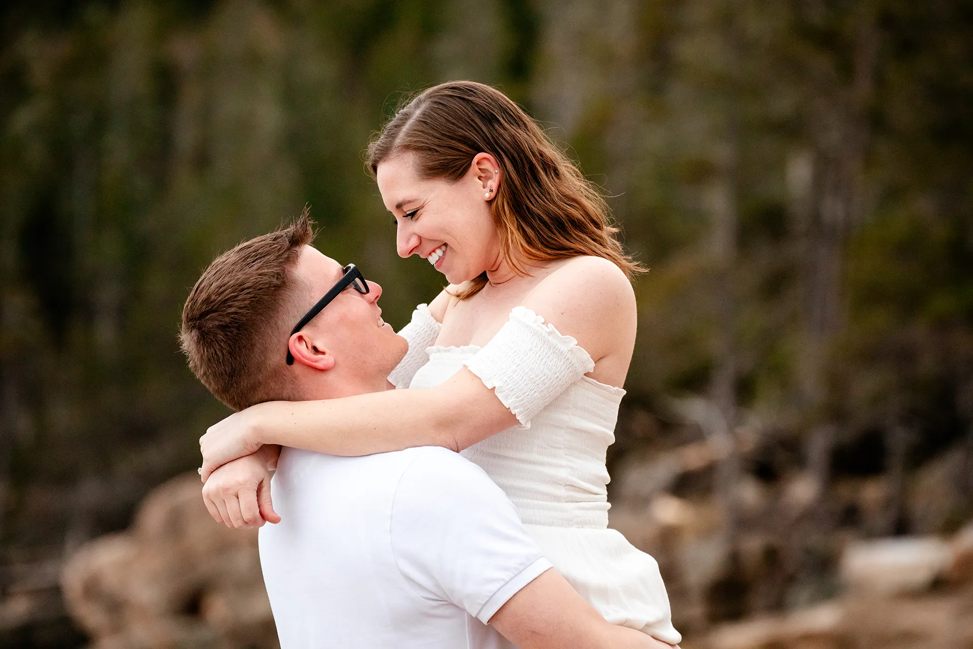 maine engagement photography chelsea mike 18 A man lifts a woman during an engagement session near the Ocean Path Trail in Acadia National Park, Maine.