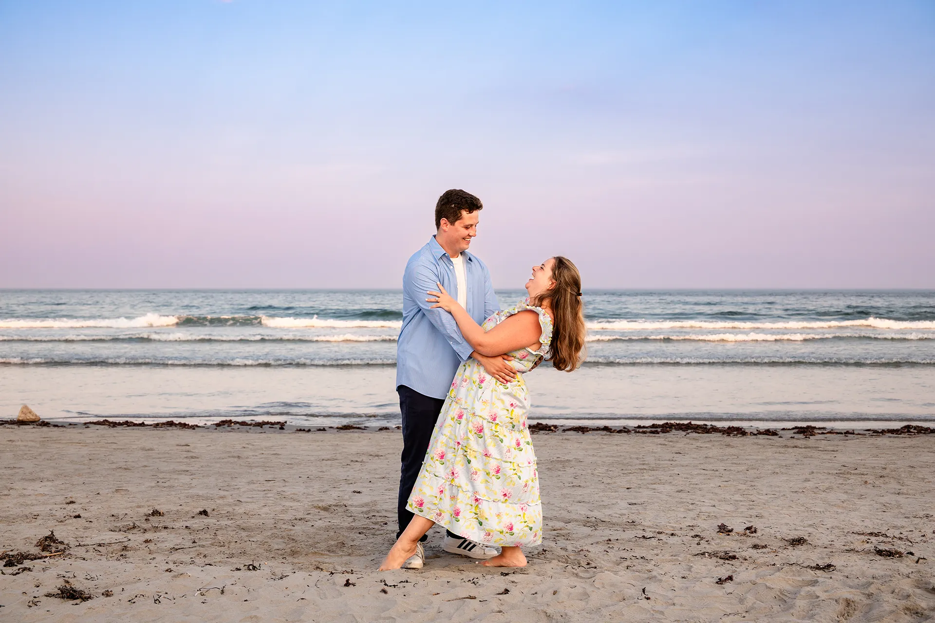 A man dips a woman during engagement portraits on Long Sands Beach in York, Maine.