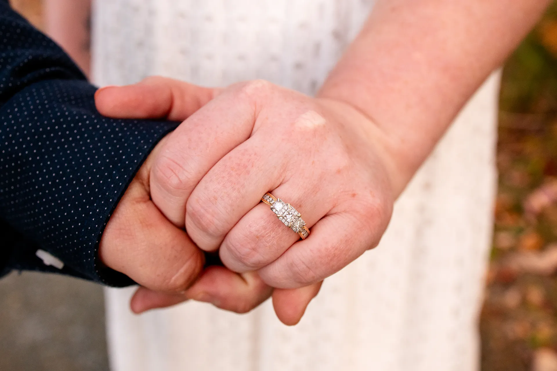 A closeup of a woman's hand wearing a diamond engagement ring during an engagement session at Acadia National Park in Bar Harbor, Maine.