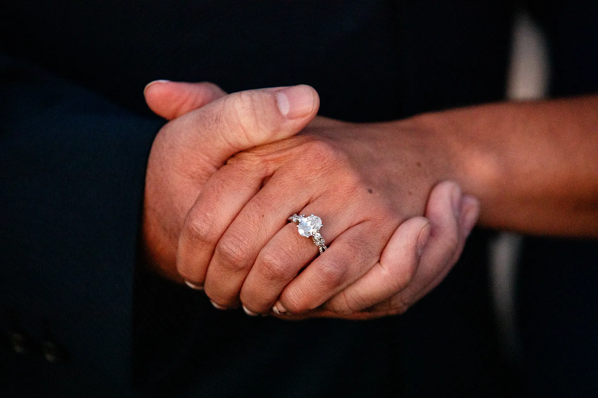 A closeup of an engaged couple's hands during an engagement session on Otter Point in Acadia National Park near Bar Harbor, Maine.