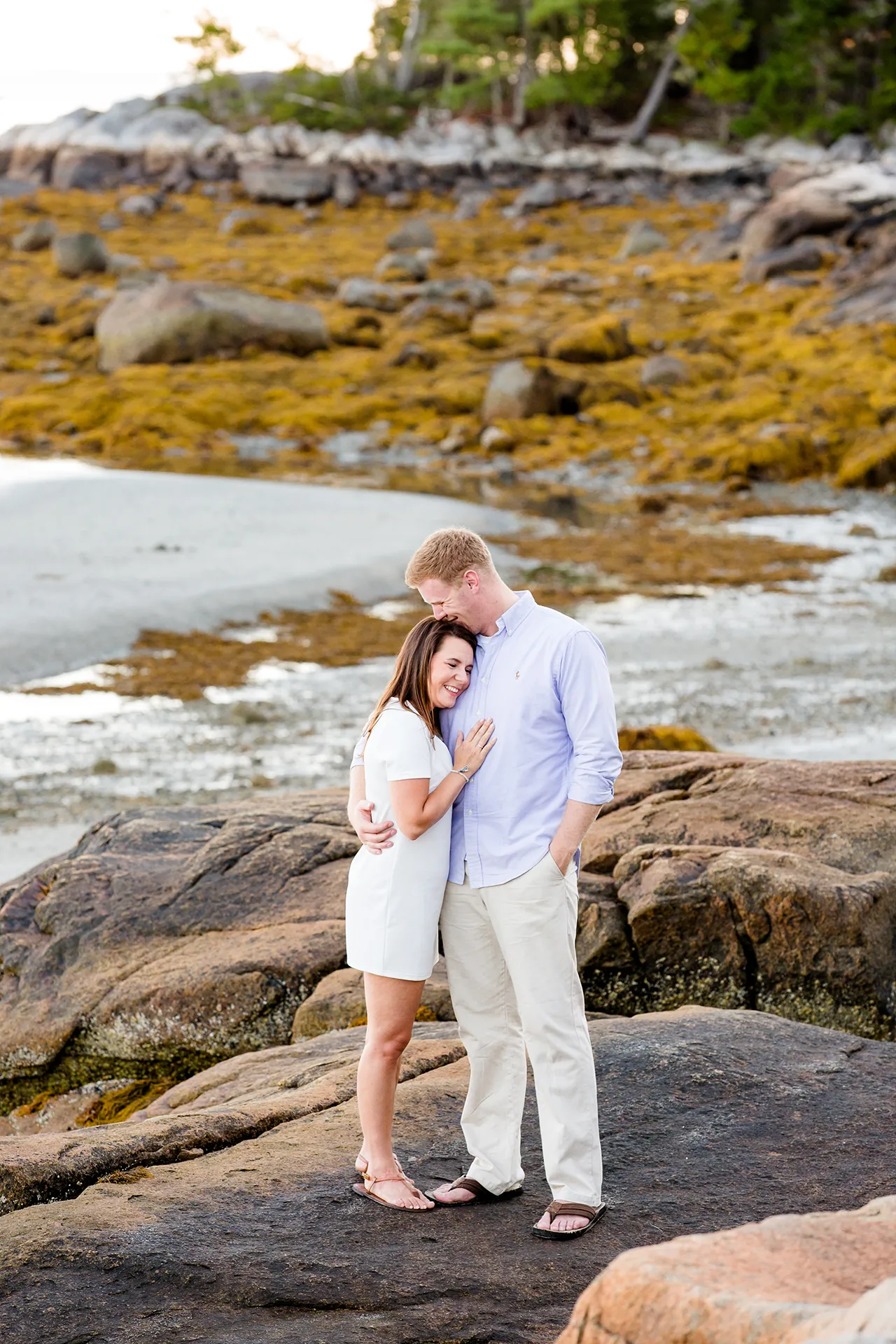maine engagement photography stephanie nick 04 An engaged couple smile as they snuggle with each other during an engagement session at Curtis Cove in Blue Hill, Maine.