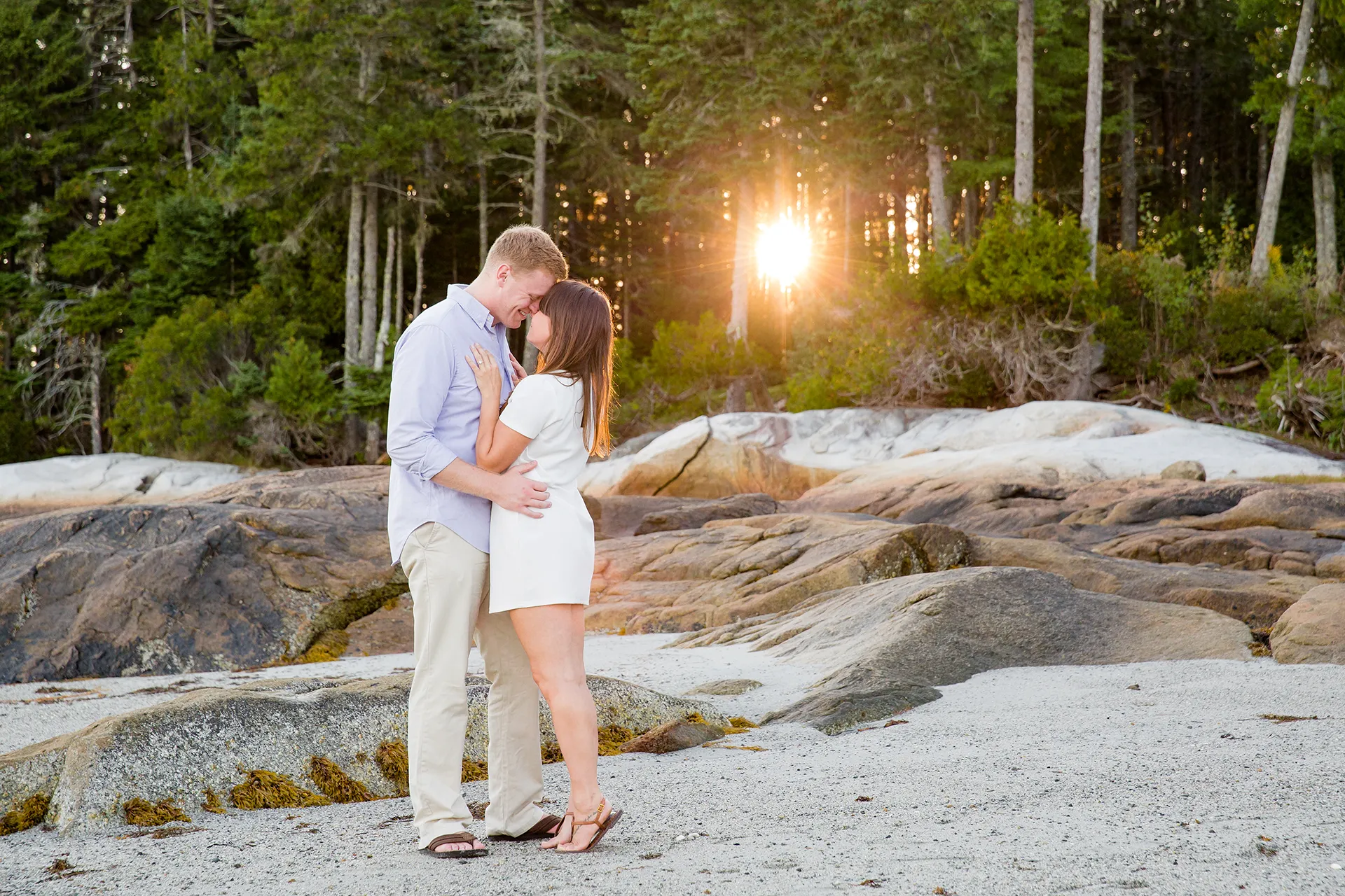 maine engagement photography stephanie nick 08 An engaged couple rest their heads together as the sun shines during an engagement session at Curtis Cove Beach in Blue Hill, Maine.