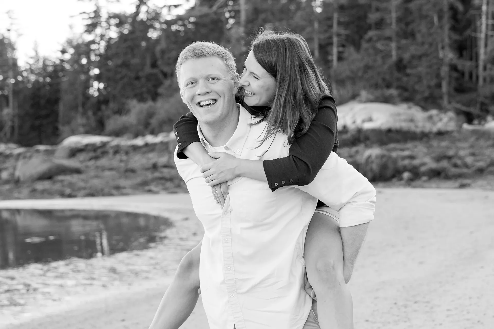 maine engagement photography stephanie nick 11 A man gives a woman a piggy back ride as they laugh during an engagement session at Curtis Cove Beach in Blue Hill, Maine.