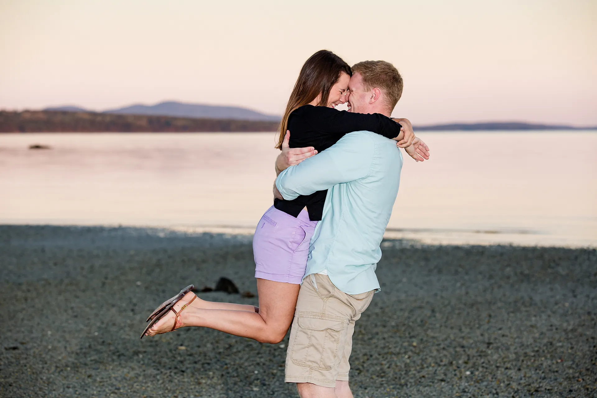 maine engagement photography stephanie nick 14 A man picks up a woman as they laugh during an engagement session at Curtis Cove Beach in Blue Hill, Maine.
