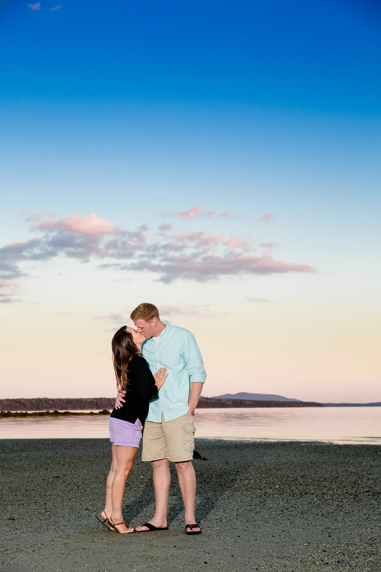maine engagement photography stephanie nick 15 A man and woman kiss as the sun sets during an engagement session at Curtis Cove Beach in Blue Hill, Maine.