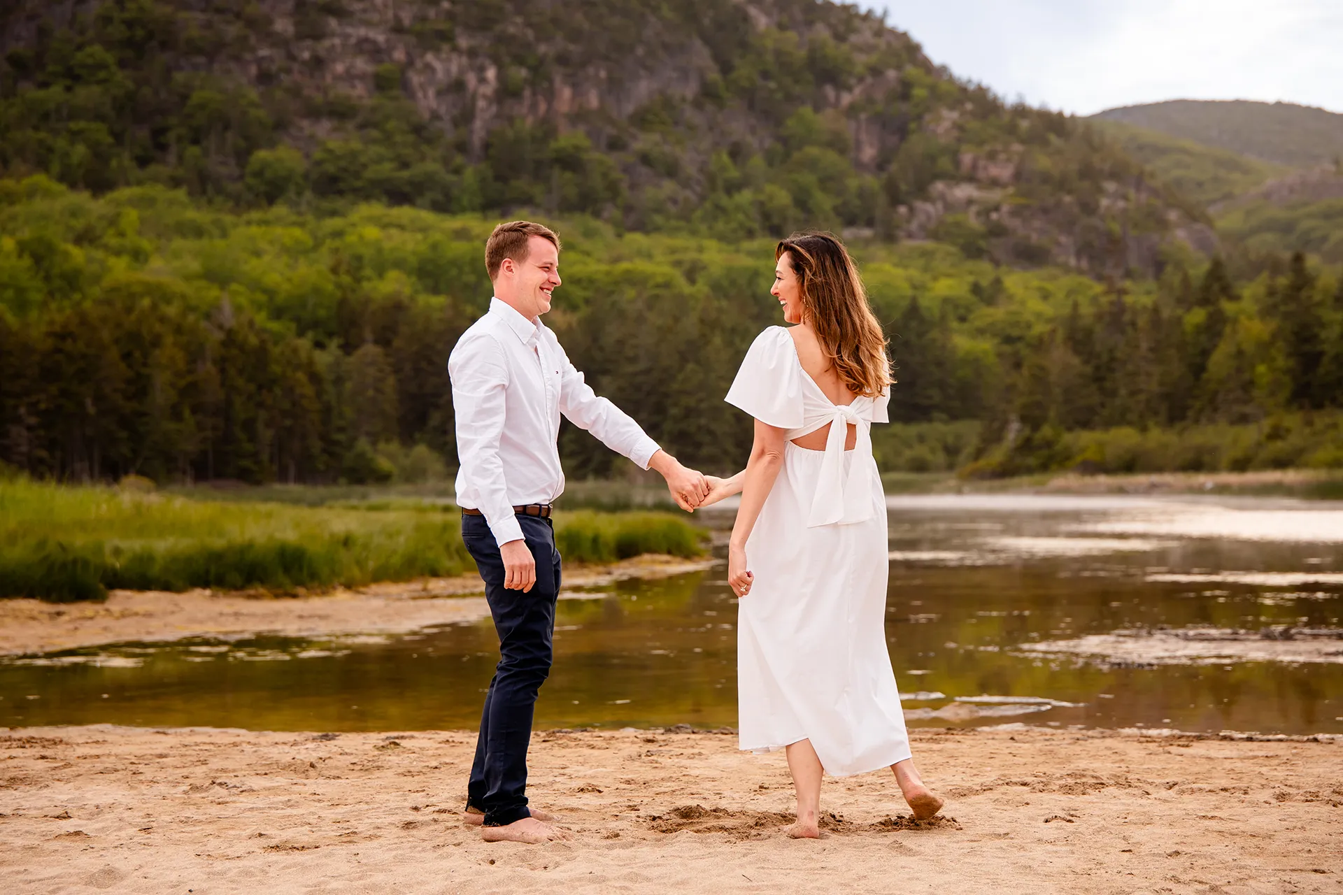 A man and woman dance together during an engagement session at Sand Beach in Acadia National Park near Bar Harbor, Maine.