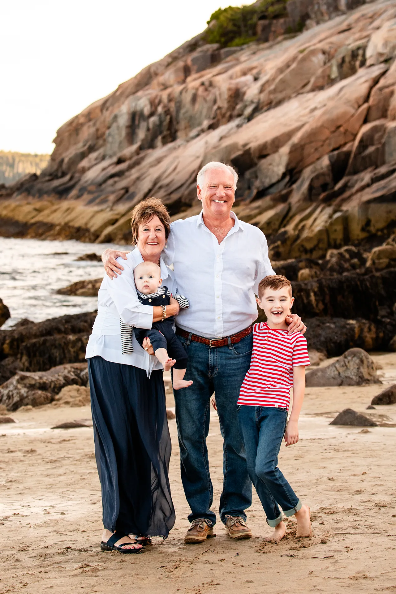 maine family photography daehler 08 Grandparents smile and pose with their grandsons during a family portrait session on Sand Beach in Acadia National Park near Bar Harbor, Maine.