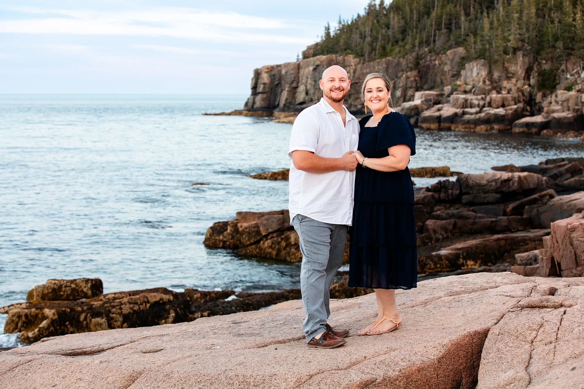 maine family photography daehler 20 A man and woman hold hands and smile during a family portrait session at Otter Cliff in Acadia National Park near Bar Harbor, Maine.