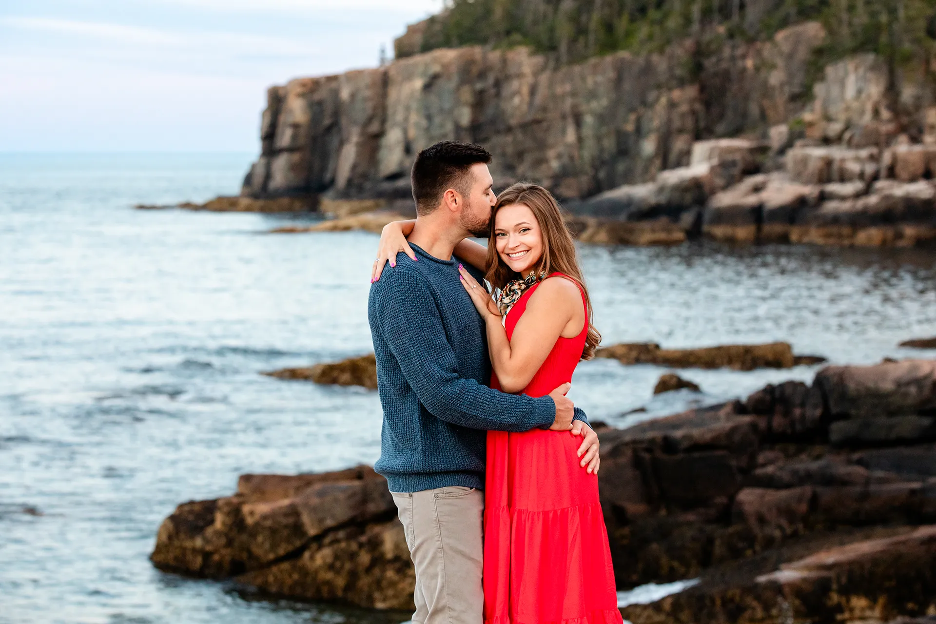maine family photography daehler 24 A woman smiles as a man kisses her on the head during a family portrait session at Otter Cliff in Acadia National Park near Bar Harbor, Maine.
