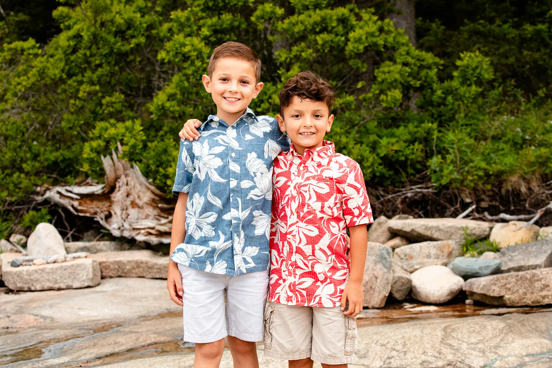 Two boys wrap their arms around each other and smile during family portraits at Grindstone Point in Winter Harbor, Maine.