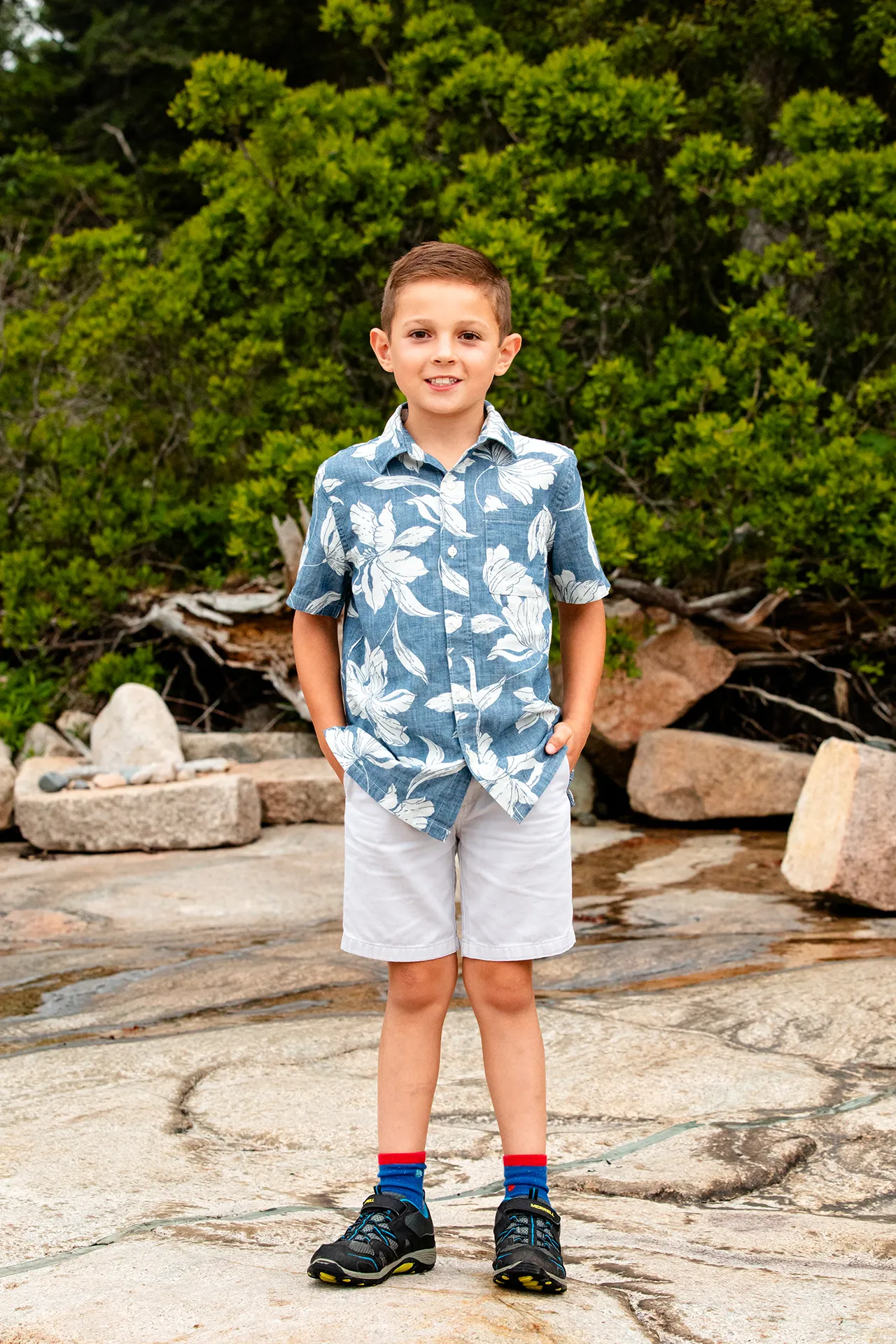 A boy smiles and poses during family portraits at Grindstone Point in Winter Harbor, Maine.