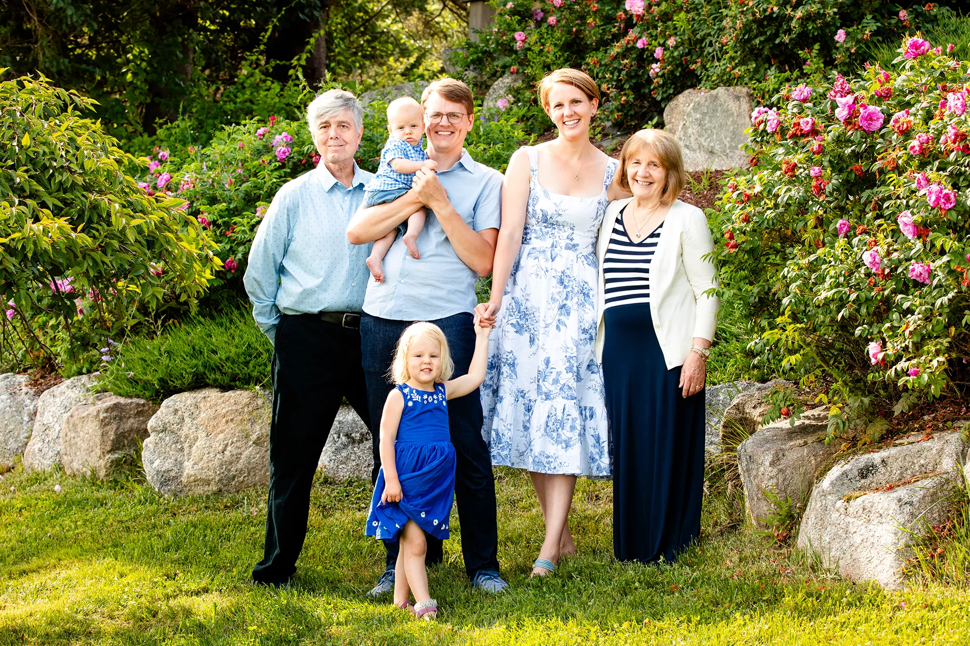maine family photography moldawer mandsager 01 A family smiles and poses in a garden during a family portrait session in Lamoine, Maine.