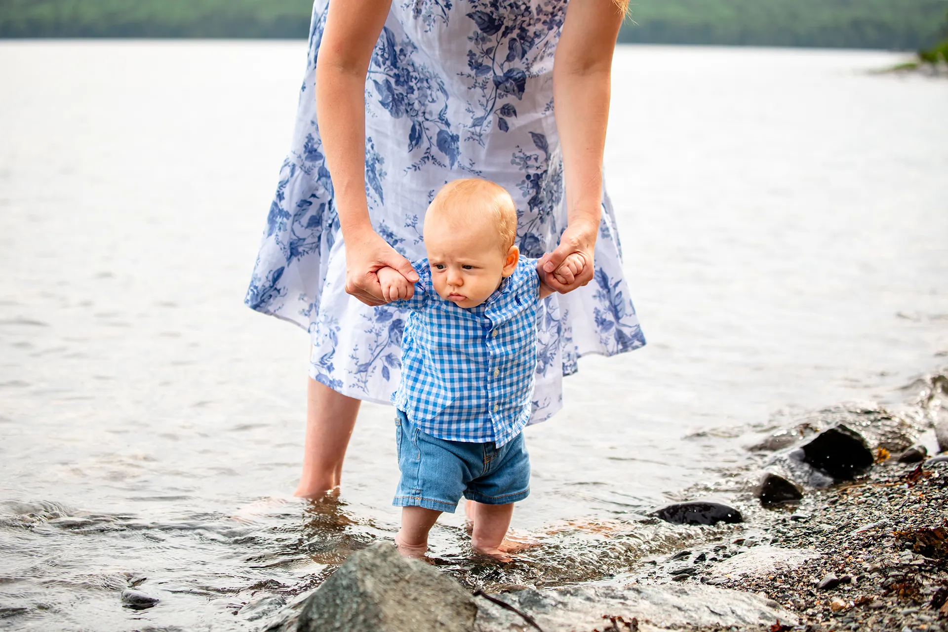 maine family photography moldawer mandsager 04 A mom helps a young boy stand in the water during a family portrait session in Lamoine, Maine.