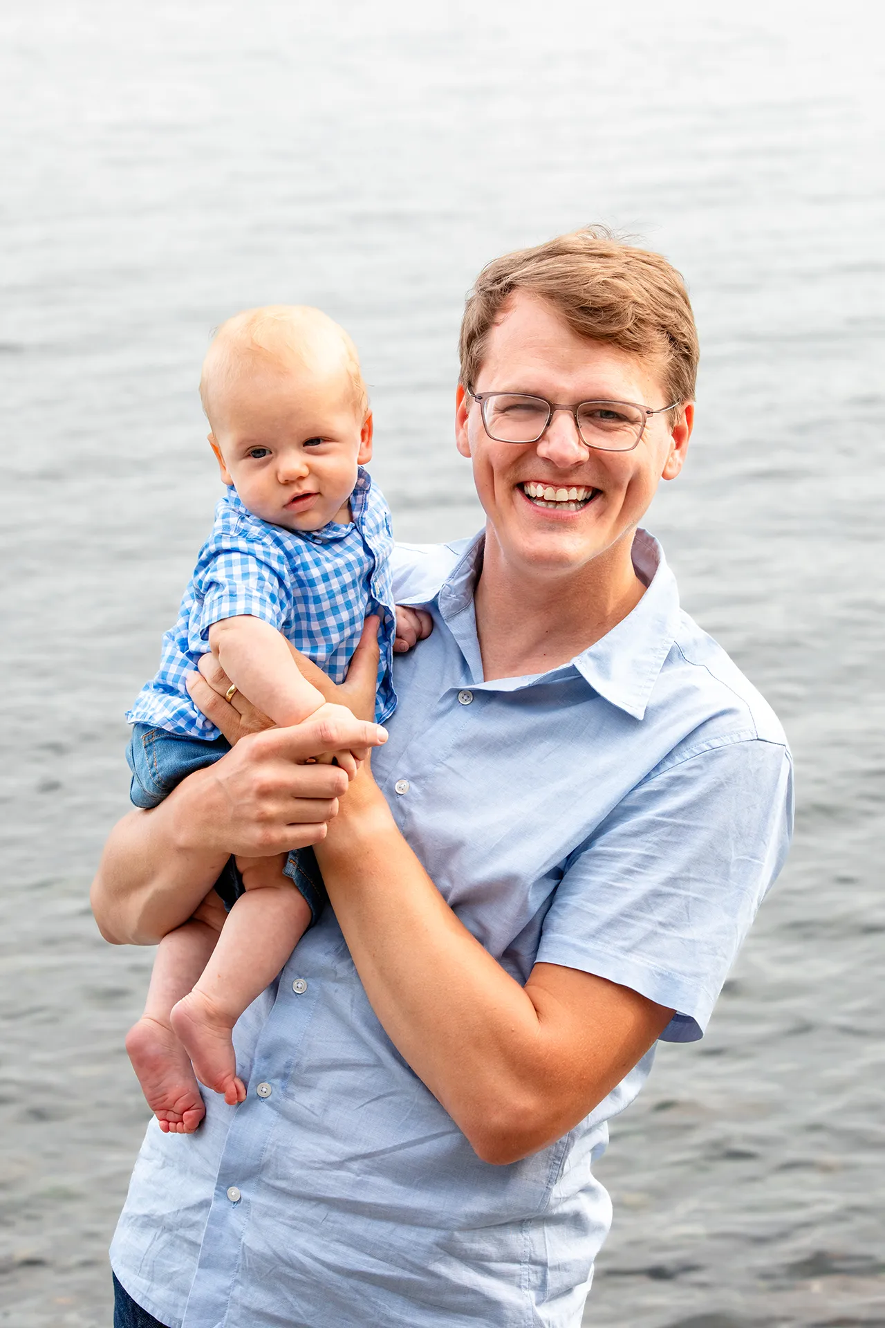 maine family photography moldawer mandsager 05 A dad smiles as he holds a young boy during a family portrait session in Lamoine, Maine.