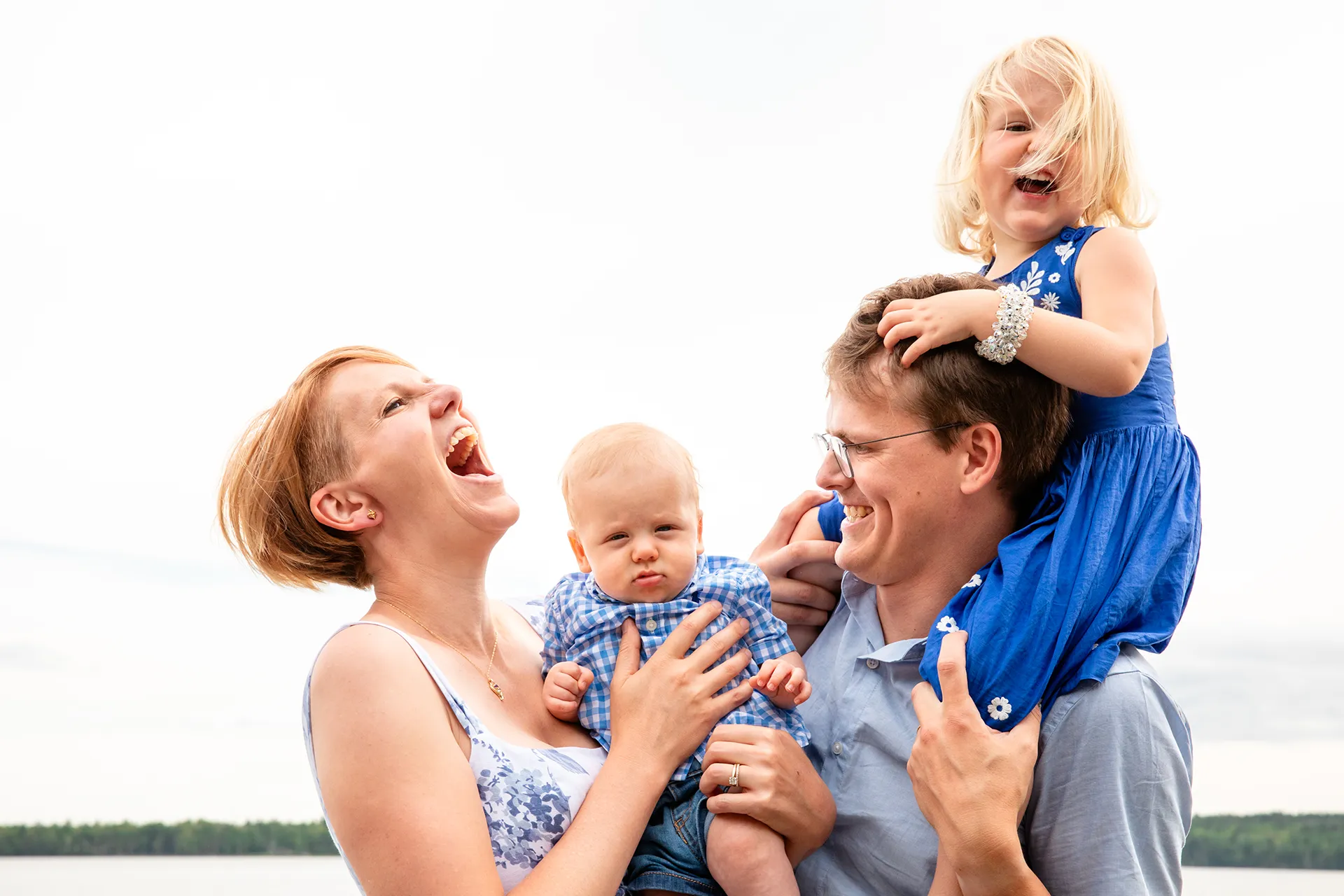 maine family photography moldawer mandsager 13 A mom, dad, and two young children laugh during a family portrait session in Lamoine, Maine.