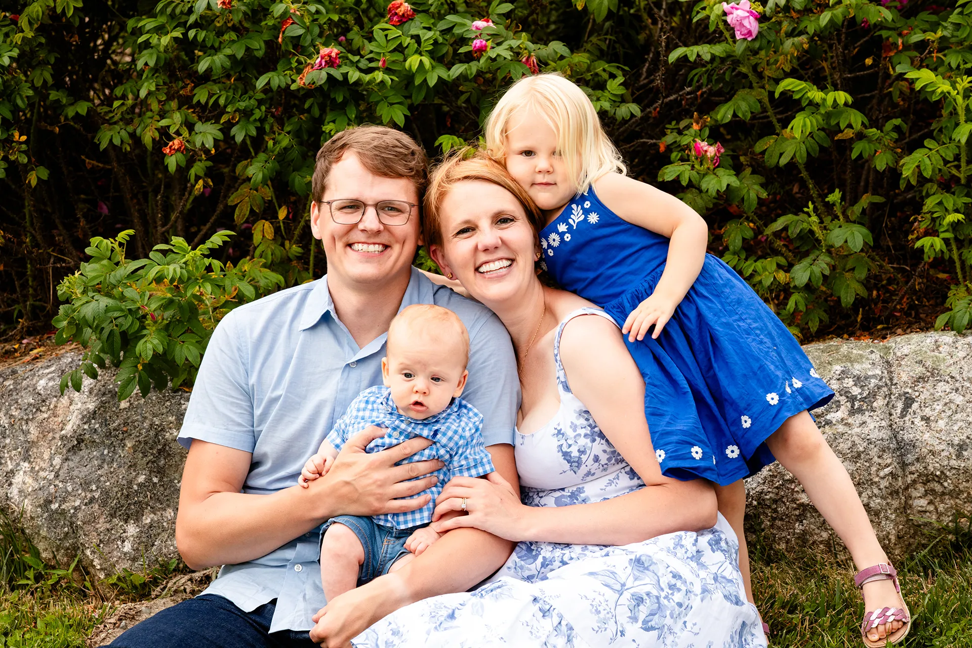 maine family photography moldawer mandsager 17 A family sits and snuggles together as they smile at the camera during a family portrait session in Lamoine, Maine.