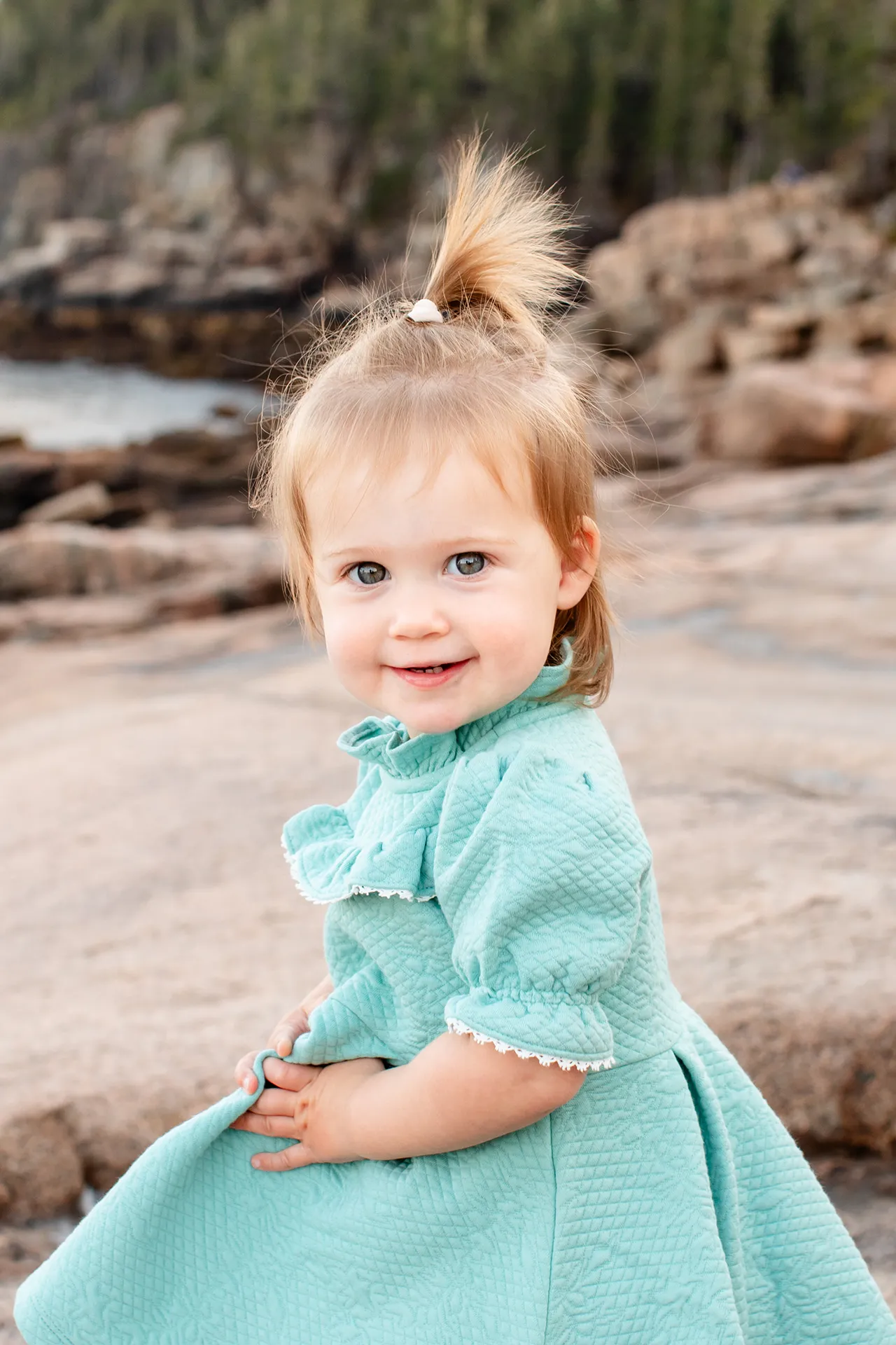 maine family photography myer 01 A young girl smiles as she poses during a family portrait session near the Ocean Path Trail in Acadia National Park.
