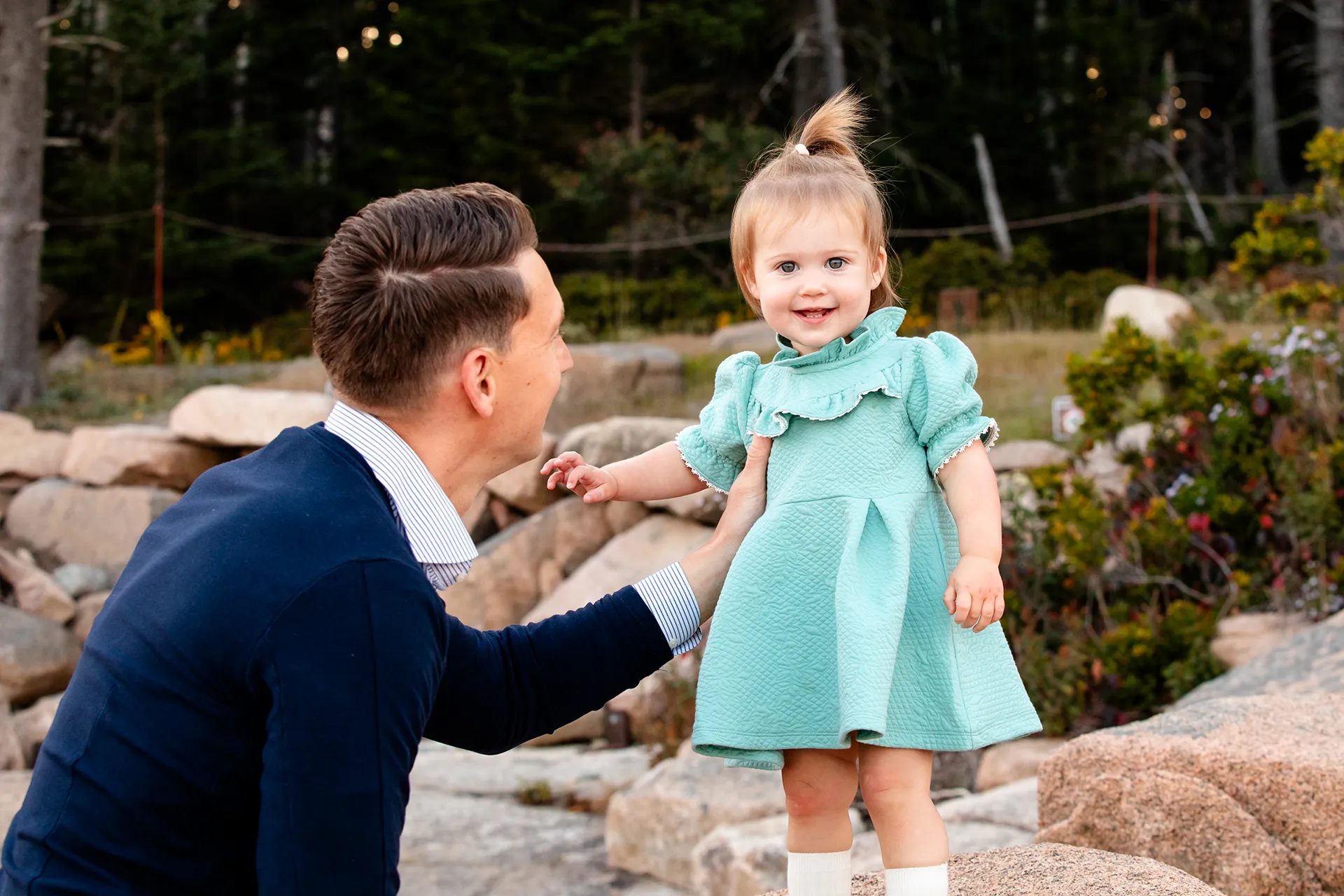 maine family photography myer 08 A young girl smiles as a dad looks at her during a family portrait session near the Ocean Path Trail in Acadia National Park.