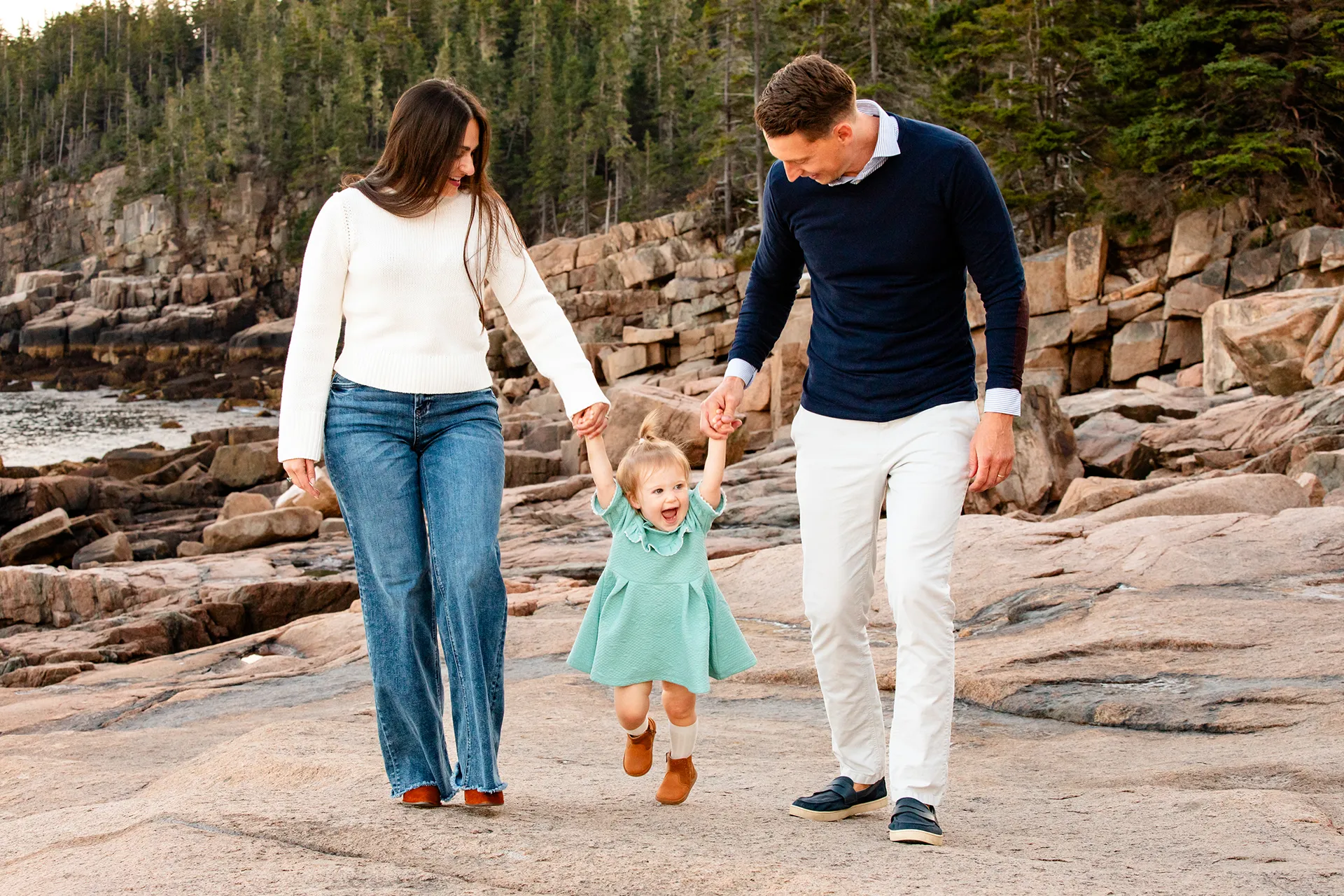 maine family photography myer 11 A young girl laughs as she walks with her mom and dad during a family portrait session near the Ocean Path Trail in Acadia National Park.