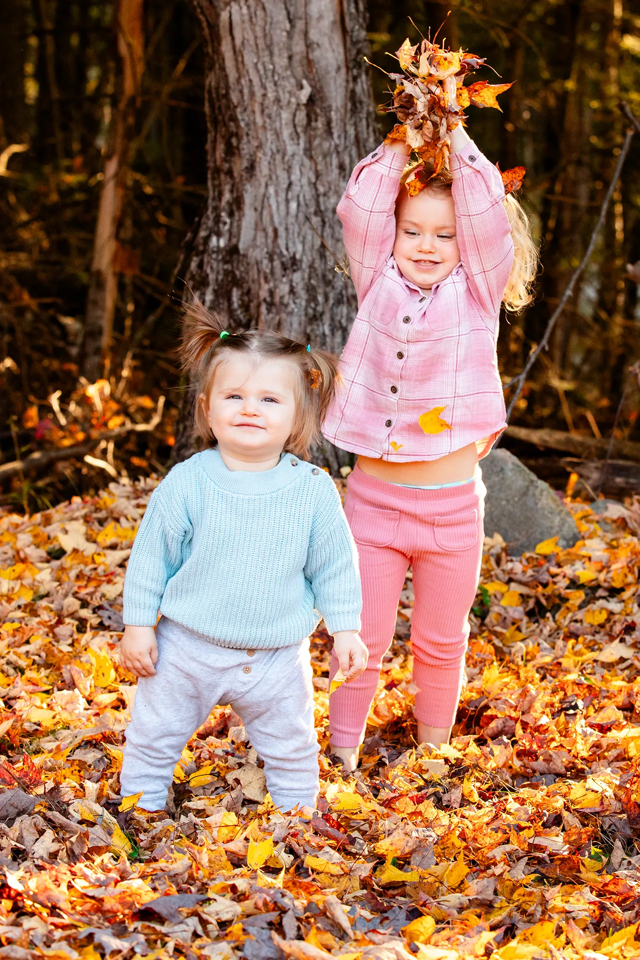maine family photography sleeper wolland 04 A girl throws leaves at her sister during a fall family portrait session near Bangor, Maine.
