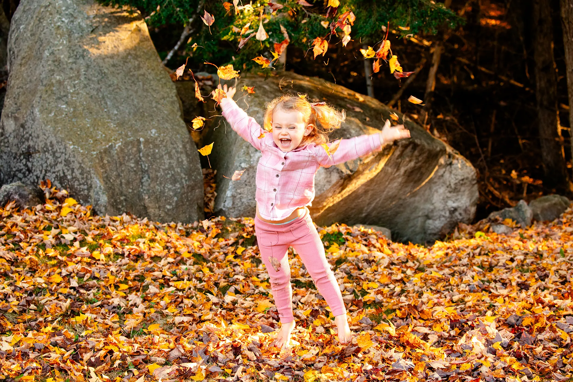 maine family photography sleeper wolland 09 A girl laughs as she throws leaves in the air during a fall family portrait session near Bangor, Maine.