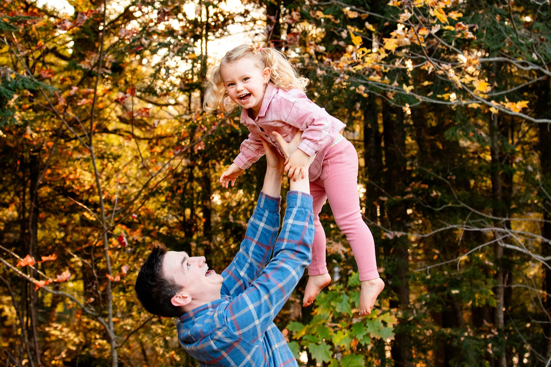 maine family photography sleeper wolland 13 A dad throws her daughter in the air as she laughs during a fall family portrait session near Bangor, Maine.