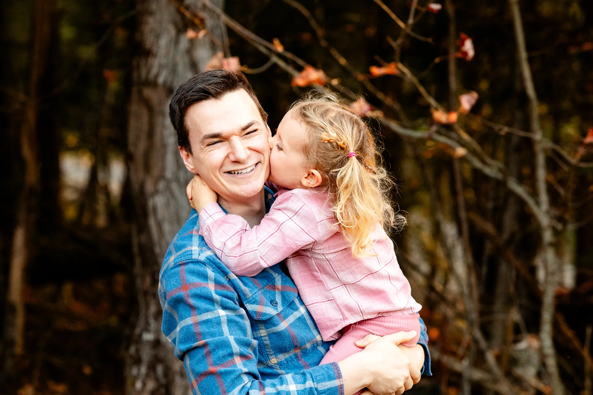 maine family photography sleeper wolland 14 A dad smiles as his daughter kisses him on the cheek during a fall family portrait session near Bangor, Maine.