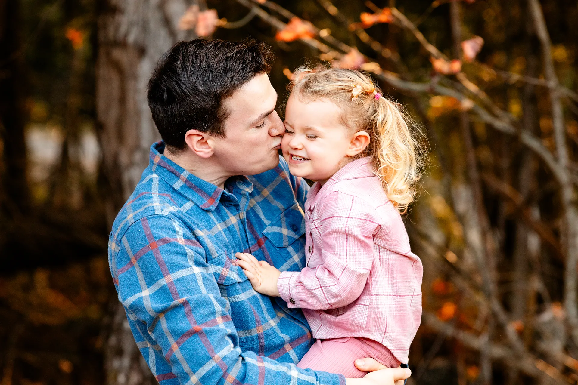 maine family photography sleeper wolland 15 A dad kisses his daughter on the cheek during a fall family portrait session near Bangor, Maine.