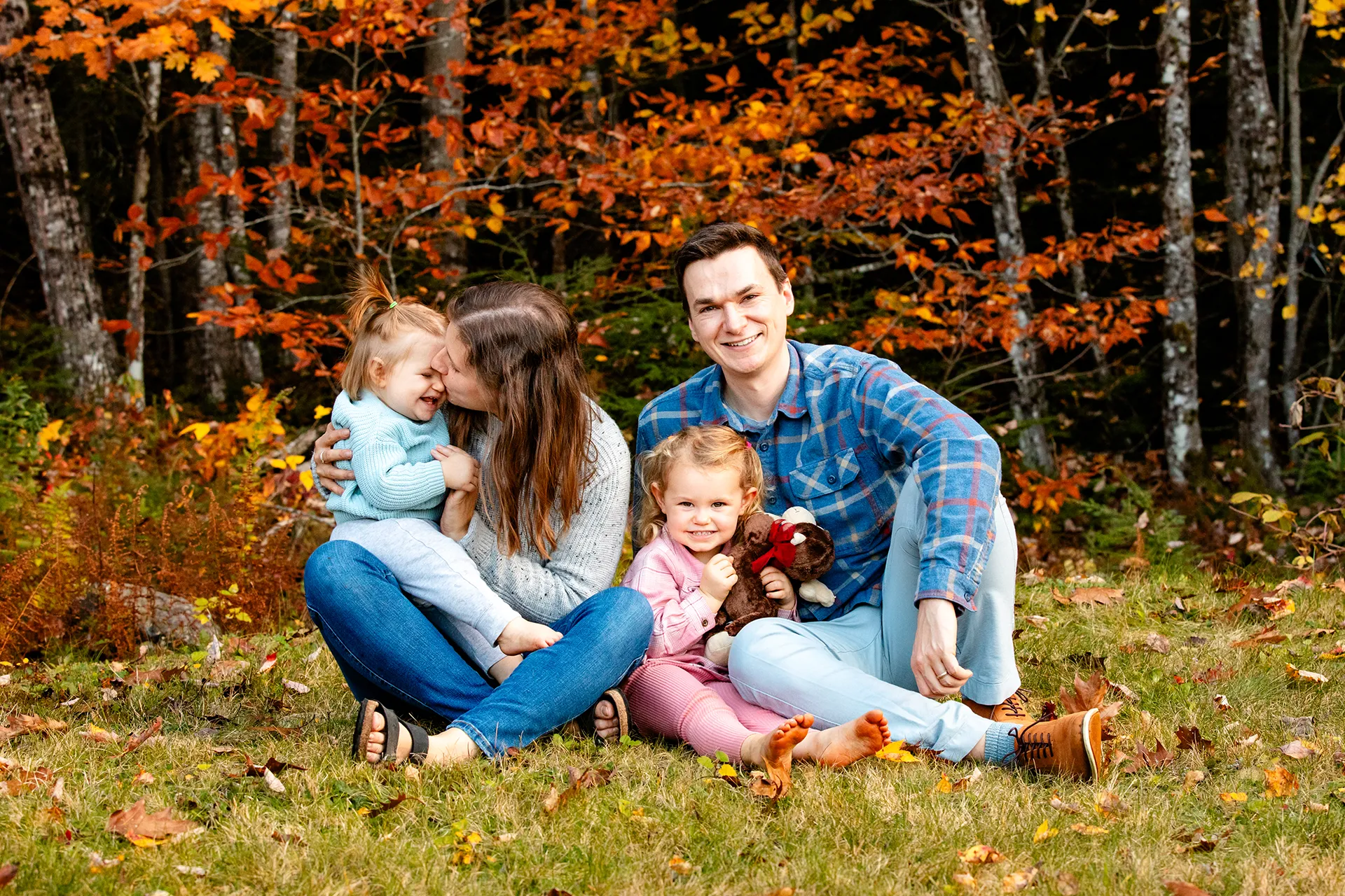 maine family photography sleeper wolland 17 A family sits in the grass and snuggles during a fall family portrait session near Bangor, Maine.