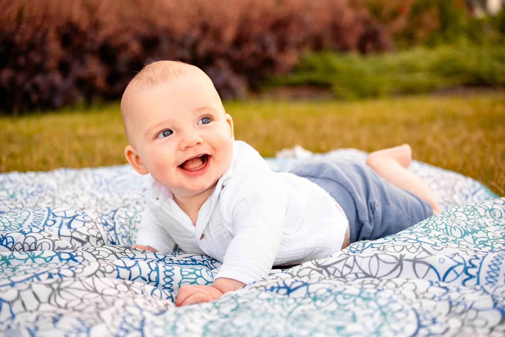 A young boy lays on a blanket and laughs during a portrait session at the Bar Harbor Inn & Spa in Bar Harbor, Maine.