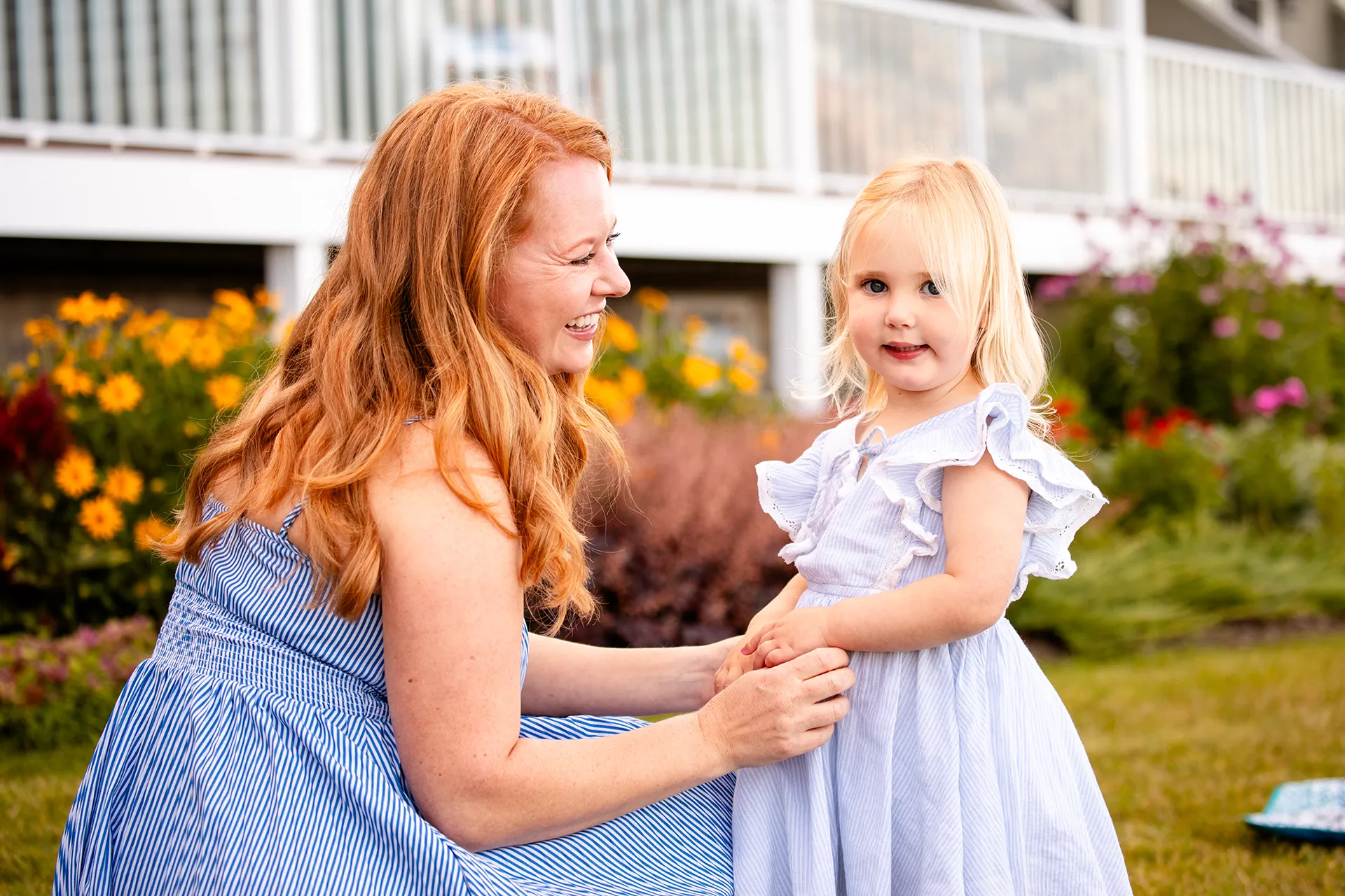 A woman holds a young girls hands as they smile during a portrait session at the Bar Harbor Inn & Spa in Bar Harbor, Maine.