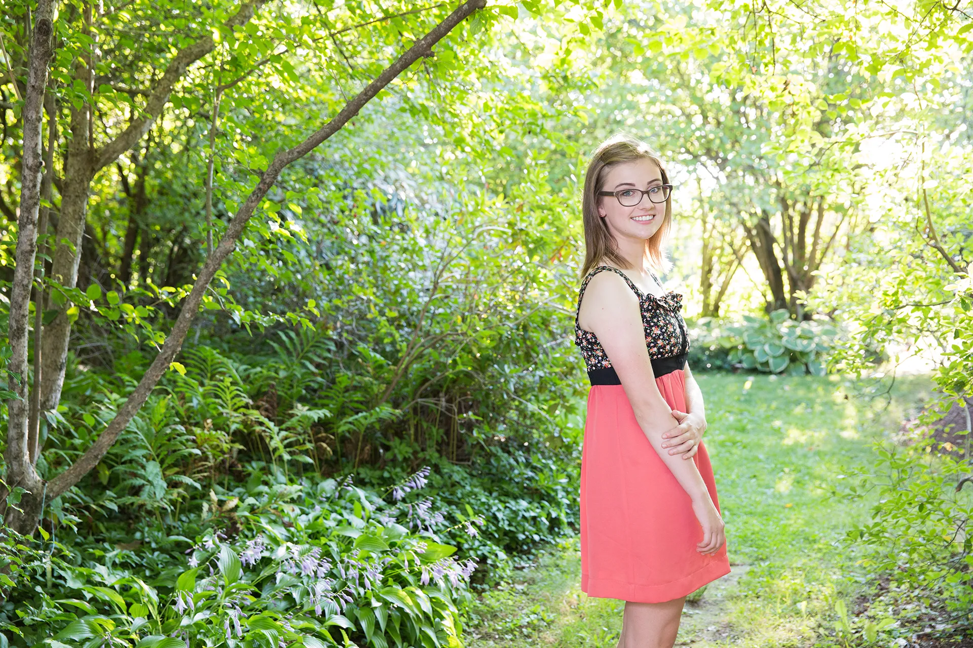 maine portrait photography emma 03 A girl smiles and poses in Littlefield Ornamental Garden at the University of Maine in Orono during a senior portrait session.
