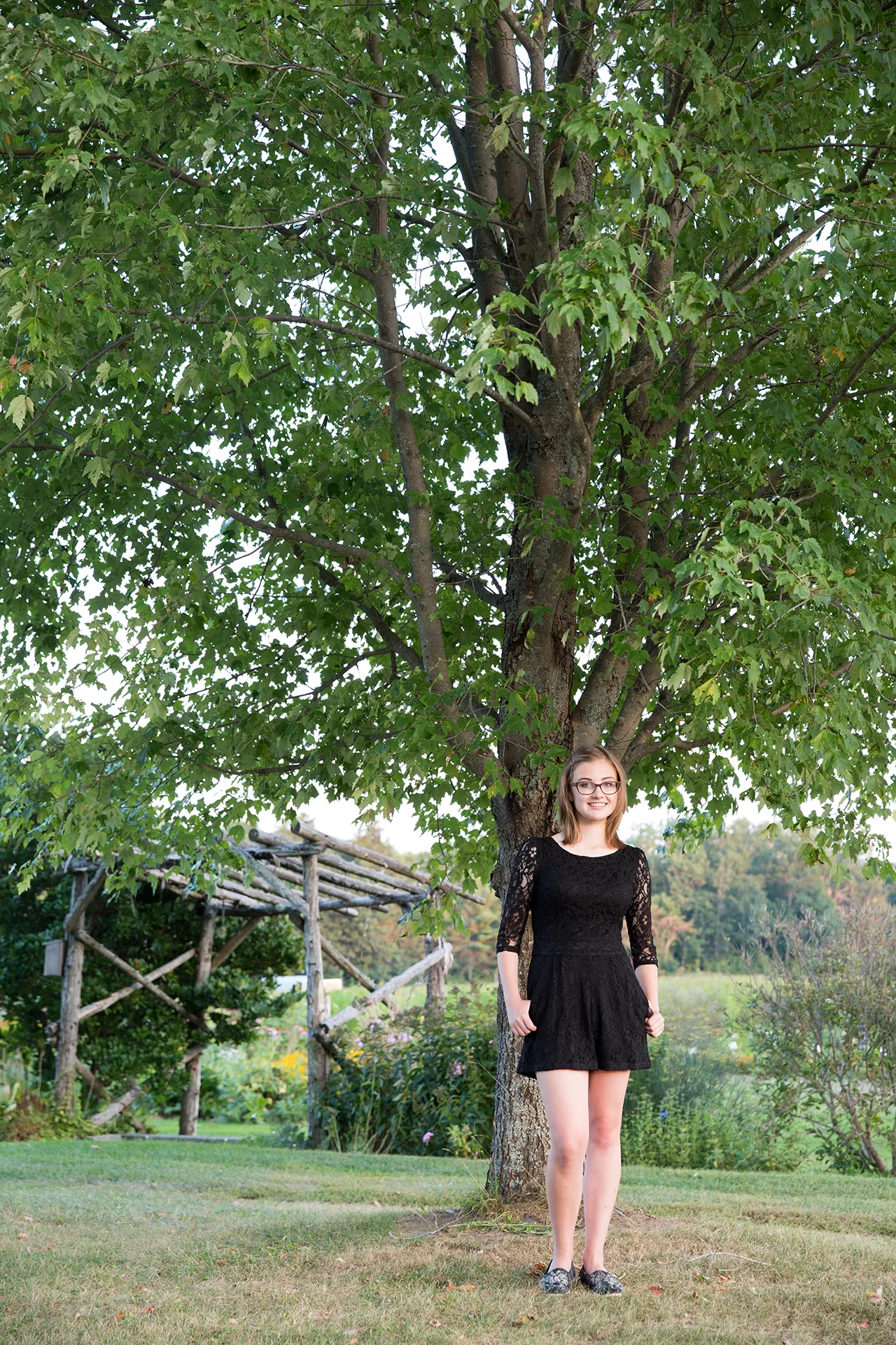 maine portrait photography emma 13 A high school senior smiles and poses in a garden during a portrait session at Rogers Farmer near the University of Maine in Old Town.