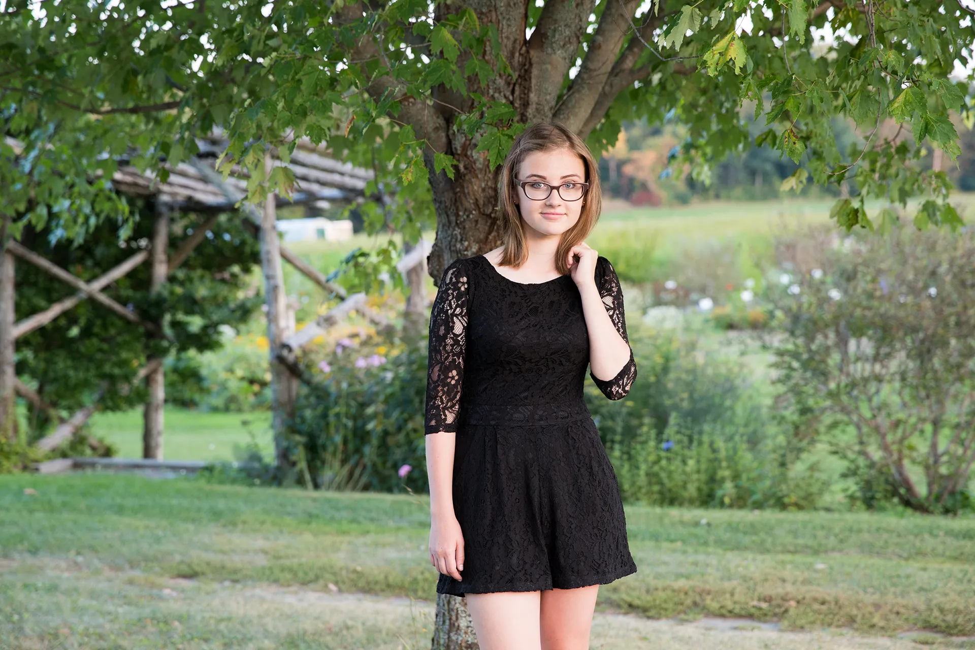 maine portrait photography emma 14 A girl poses in a garden during a senior portrait session at Rogers Farmer near the University of Maine in Old Town.