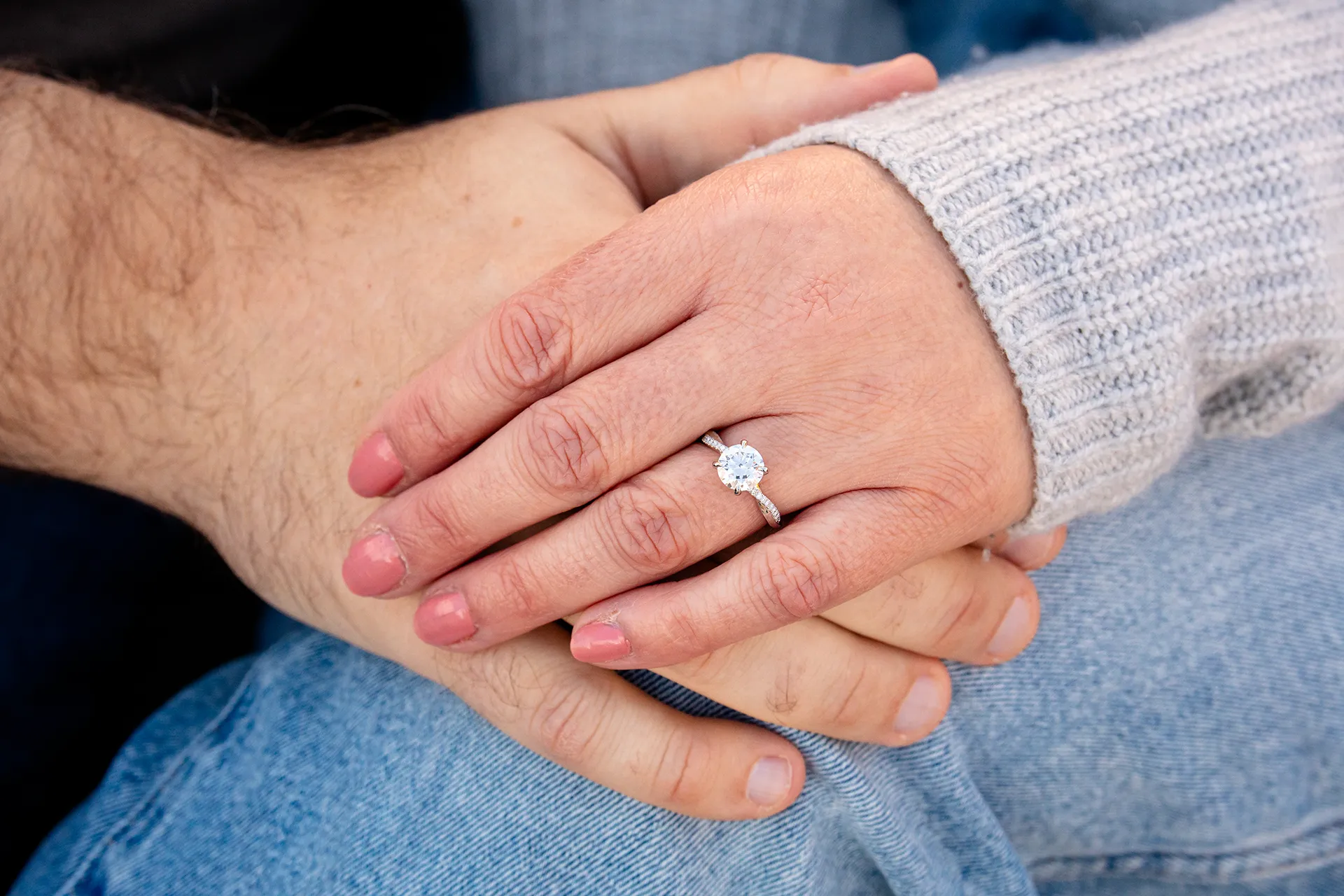 A closeup of a man and woman's hands during an engagement session at the Bar Harbor Inn and Spa near Acadia National Park.