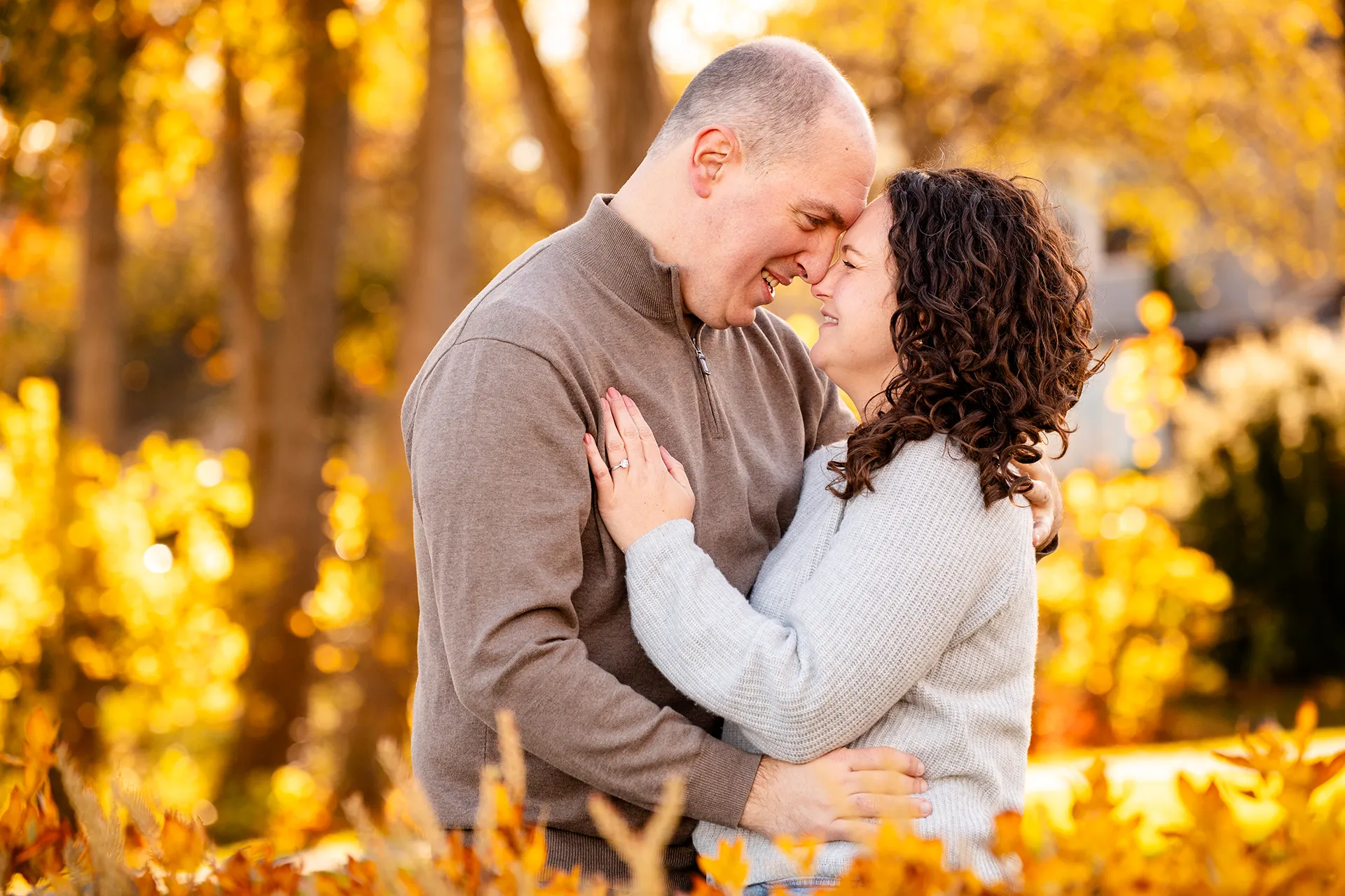 A couple rest their foreheads together during engagement portraits at the Bar Harbor Inn and Spa near Acadia National Park.