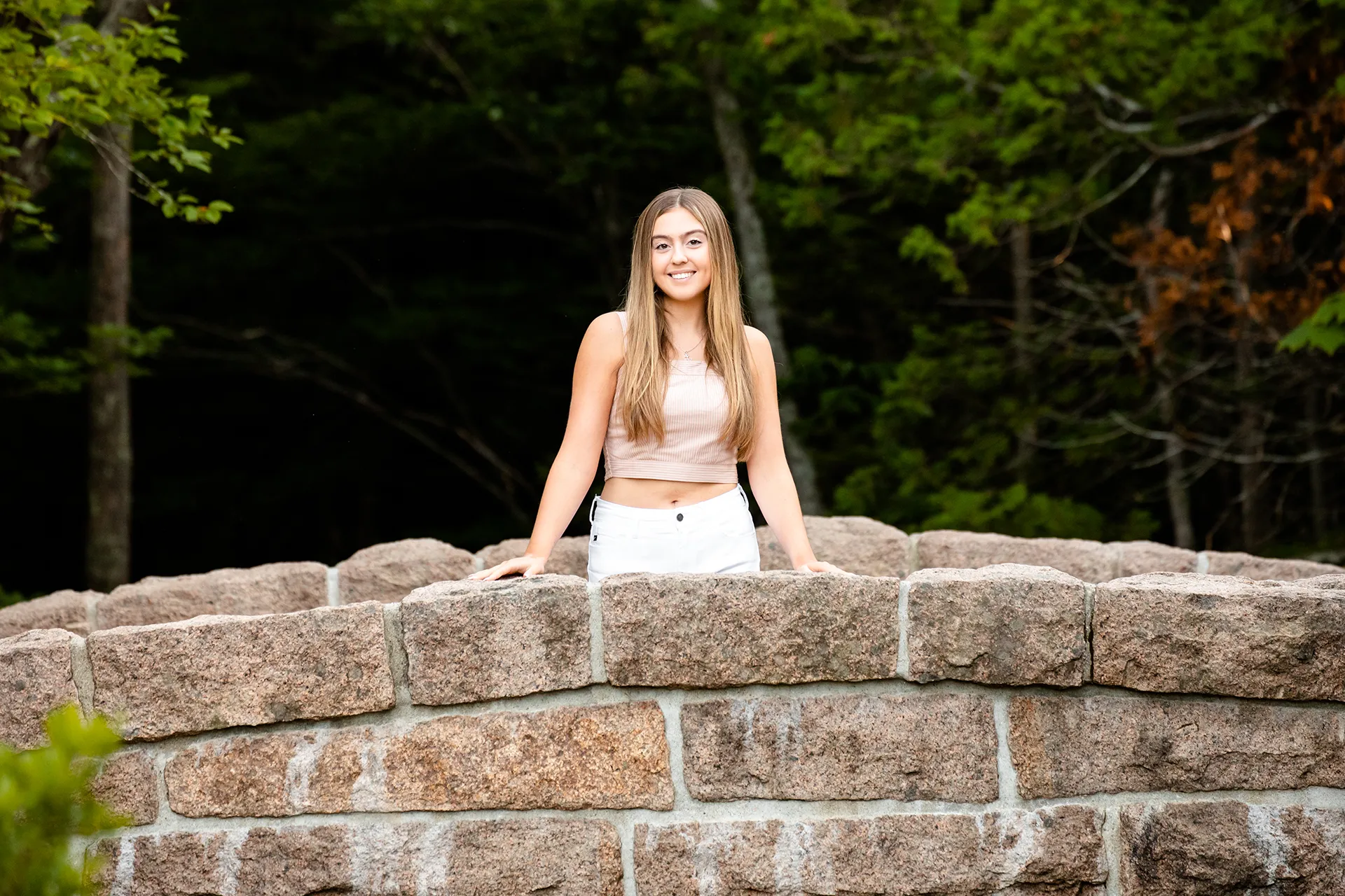 maine senior photography brooke 01 A high school senior smiles and poses on a stone bridge during a portrait session at Jordan Pond in Acadia National Park, Maine.