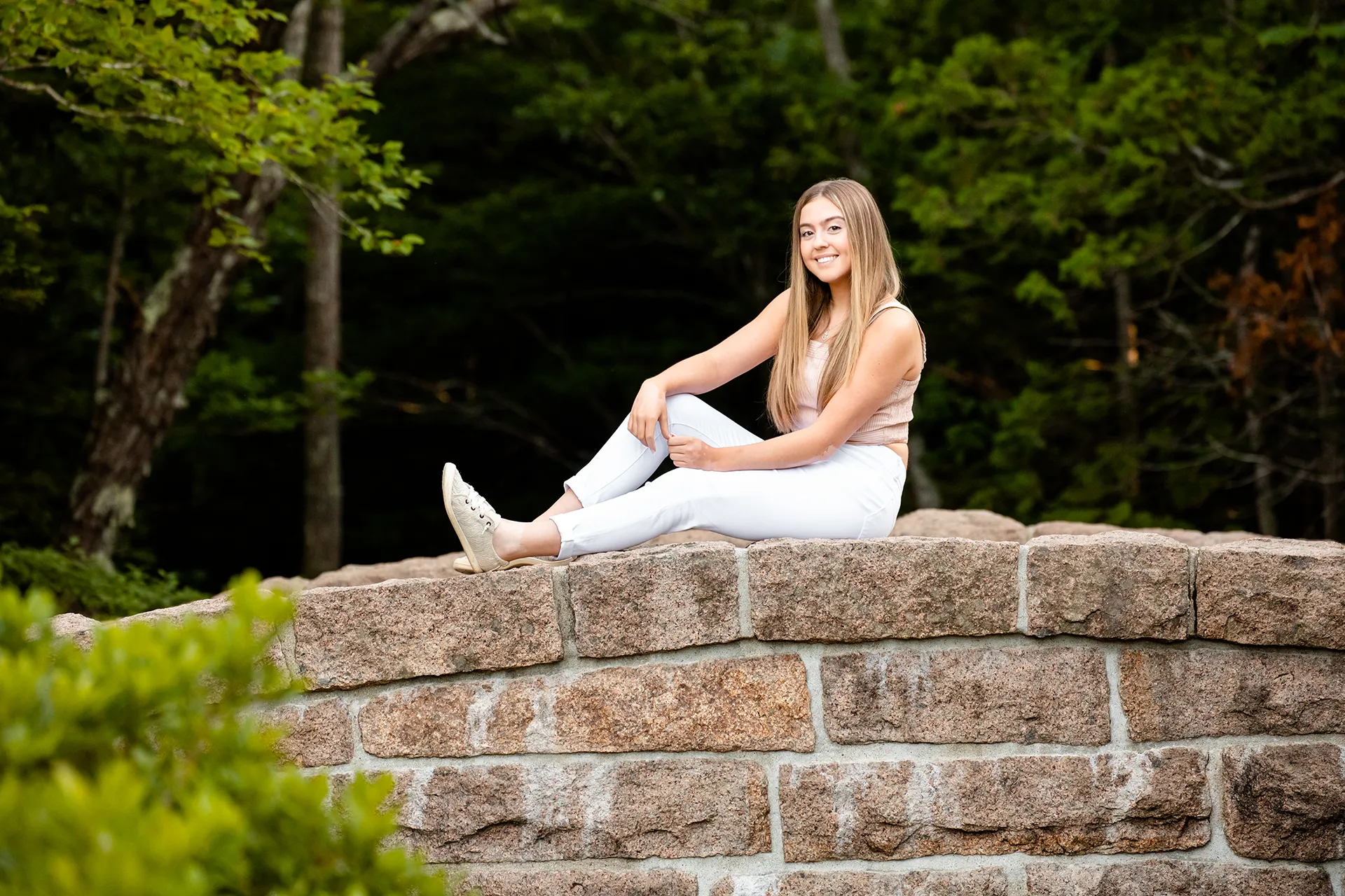 maine senior photography brooke 03 A high school senior smiles and sits on a stone bridge during a portrait session at Jordan Pond in Acadia National Park near Bar Harbor, Maine.