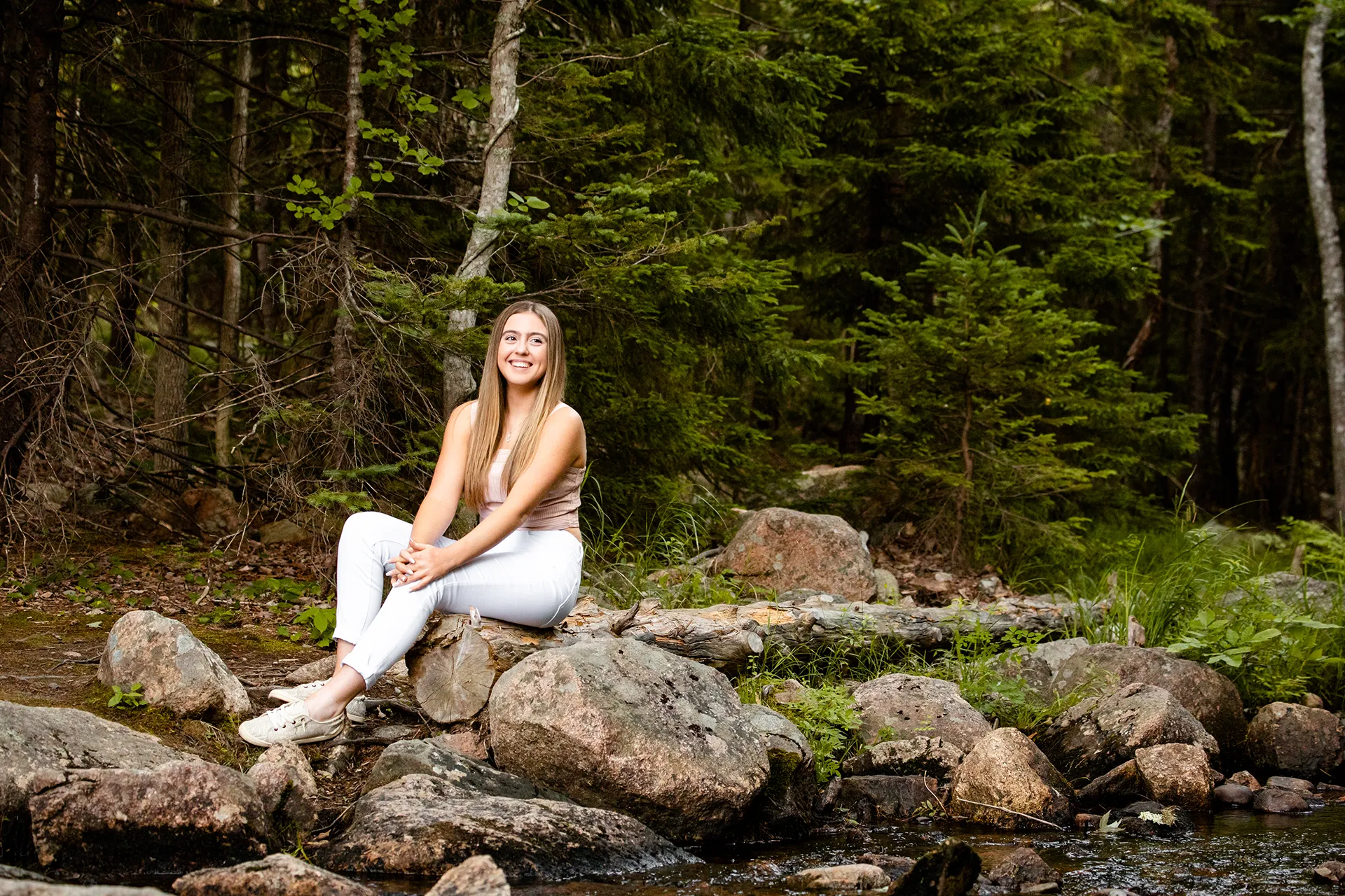 maine senior photography brooke 06 A high school senior poses on a rock near a stream during a portrait session at Jordan Pond in Acadia National Park, Maine.