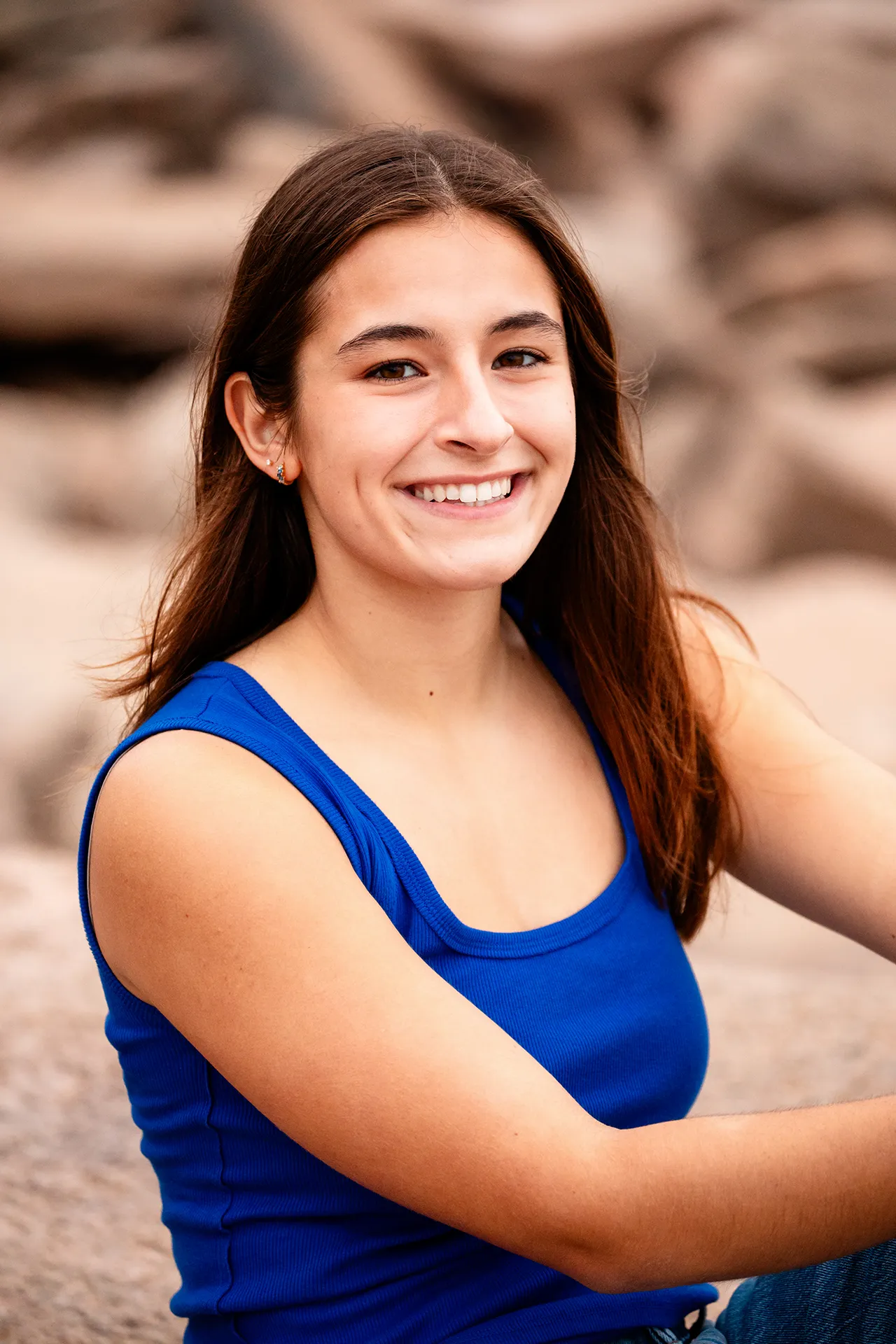 A high school senior sits and poses during a portrait session off the Ocean Path in Acadia National Park near Bar Harbor, Maine.