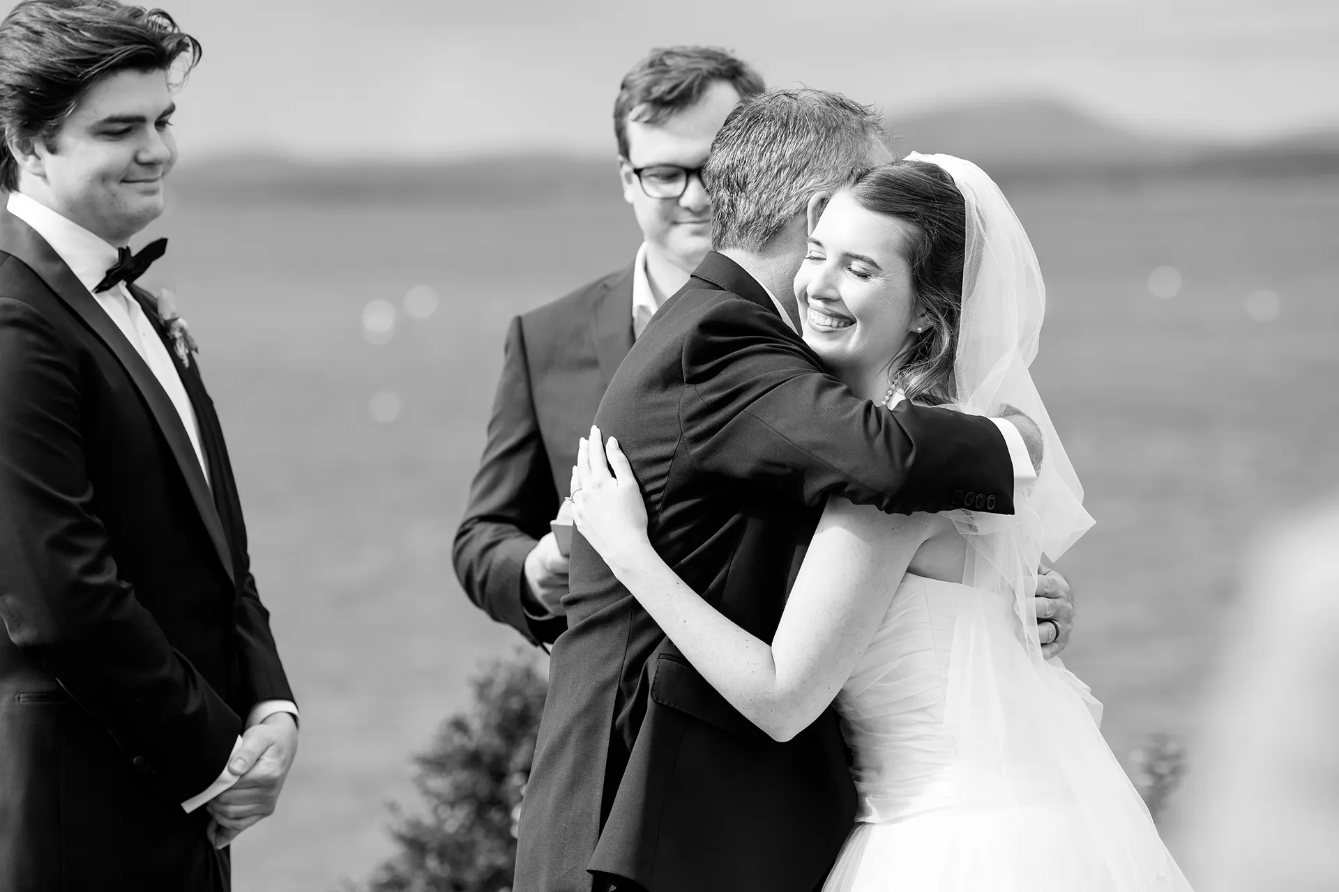A bride smiles as she hugs her dad during a wedding ceremony at the Bar Harbor Inn and Spa near Acadia National Park in Maine.