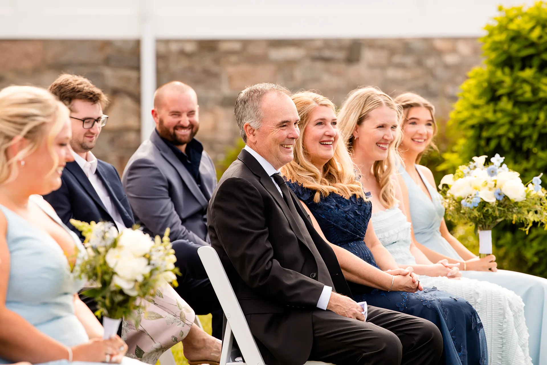 Wedding guests laugh as they listen to a wedding ceremony at the Bar Harbor Inn and Spa in Maine.