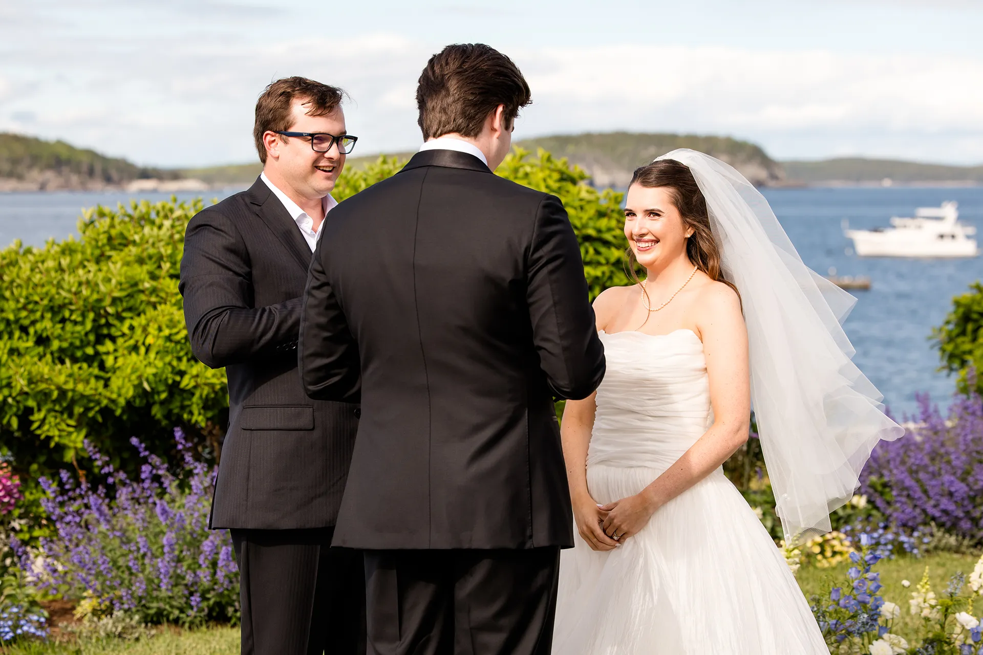 A bride smiles at a groom during a wedding ceremony at the Bar Harbor Inn and Spa near Acadia National Park in Maine.