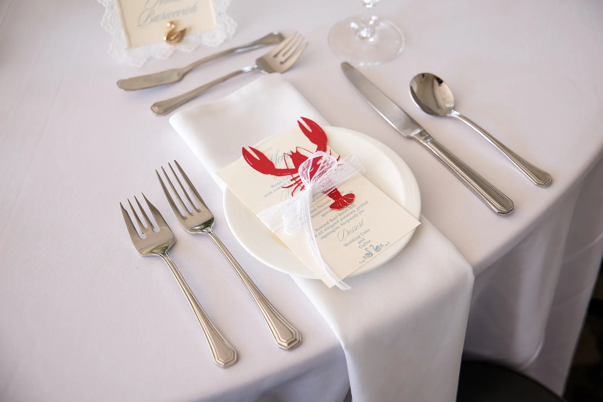 A closeup of a lobster themed table setting for a wedding reception in the Porcupine Room at the Bar Harbor Inn and Spa in Maine.