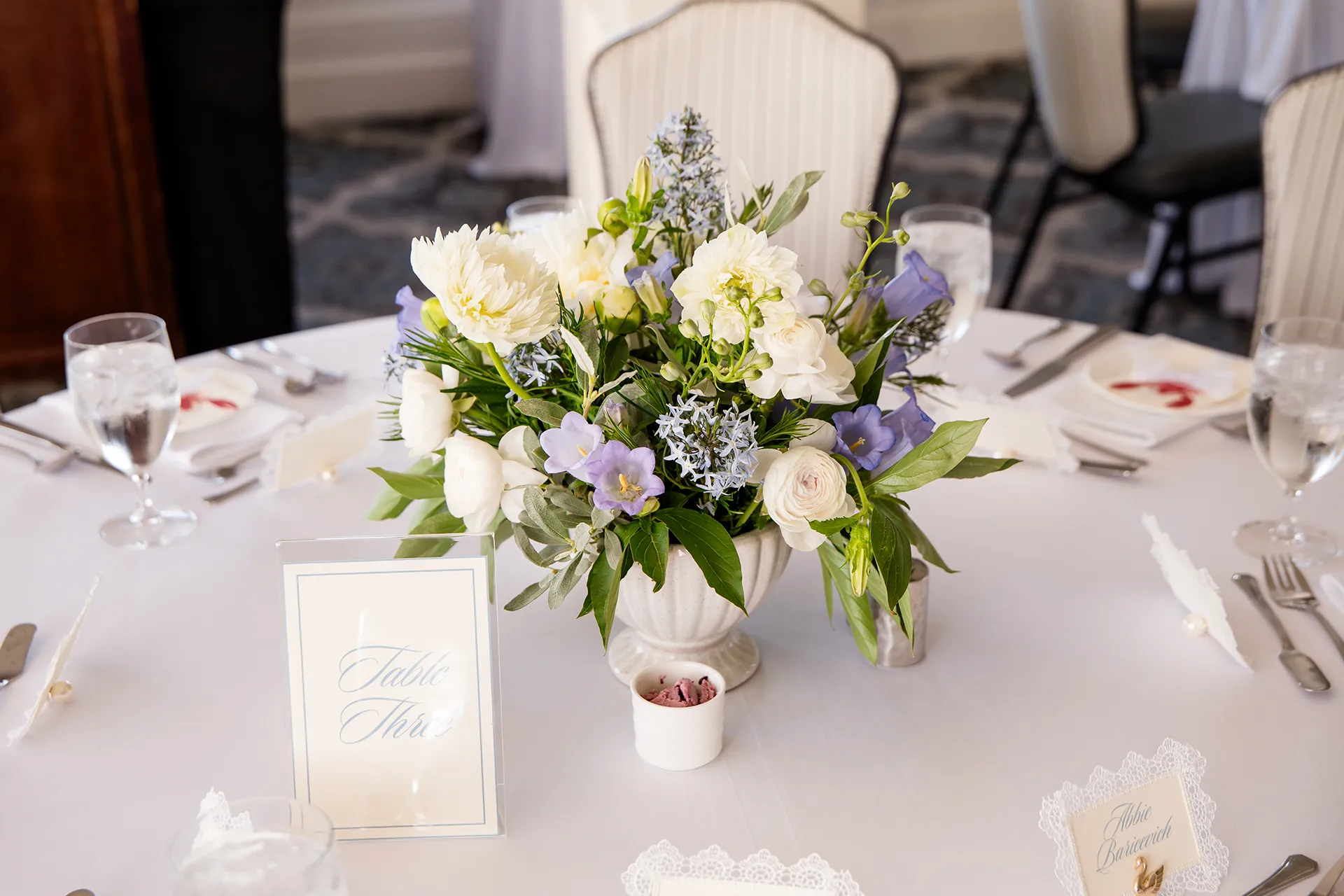 A closeup of a purple and while floral centerpieces for a wedding reception in the Porcupine Room at the Bar Harbor Inn and Spa in Maine.