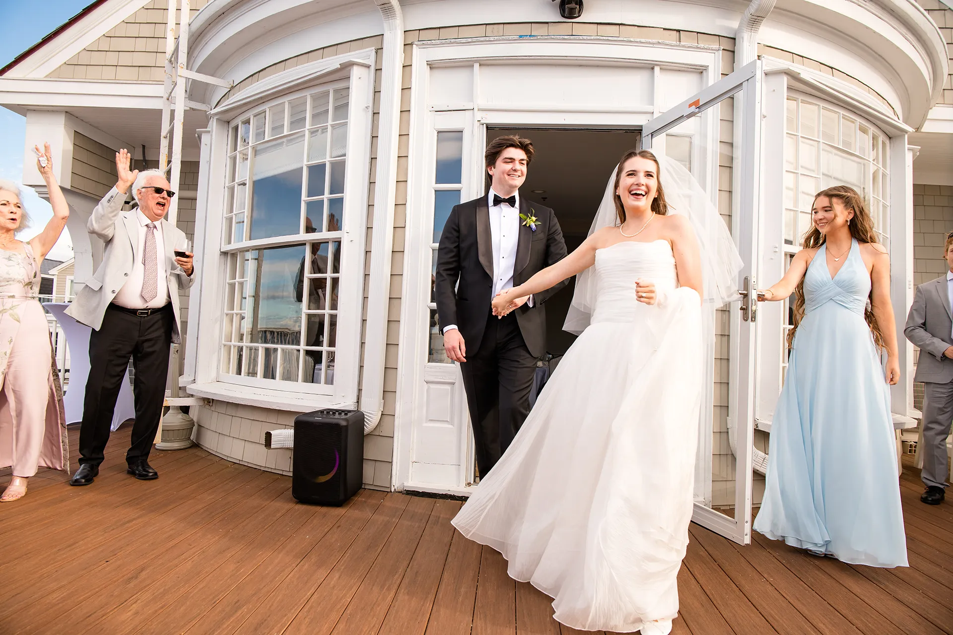 A bride and groom are welcomed into their wedding reception by guests at the Bar Harbor Inn and Spa near Acadia National Park in Maine.