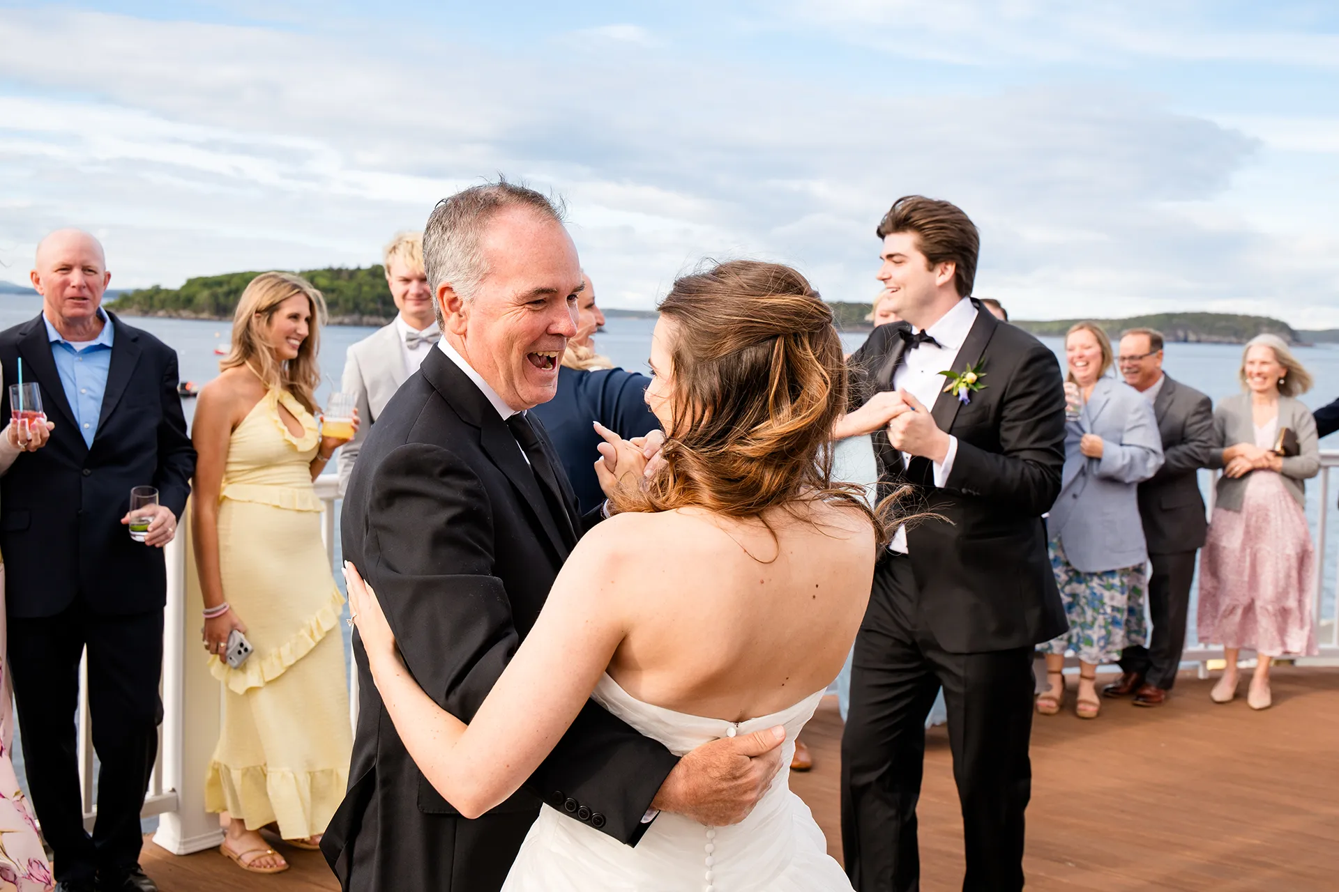 A dad laughs while he dances with a bride during a wedding reception at the Bar Harbor Inn and Spa near Acadia National Park in Maine.